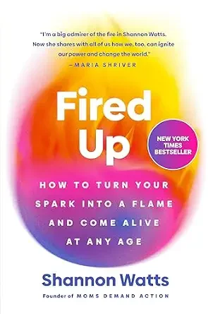 Book cover titled "Fired Up" by Shannon Watts with a colorful background blending orange, pink, yellow, purple, and blue. Includes quote from Maria Shriver.