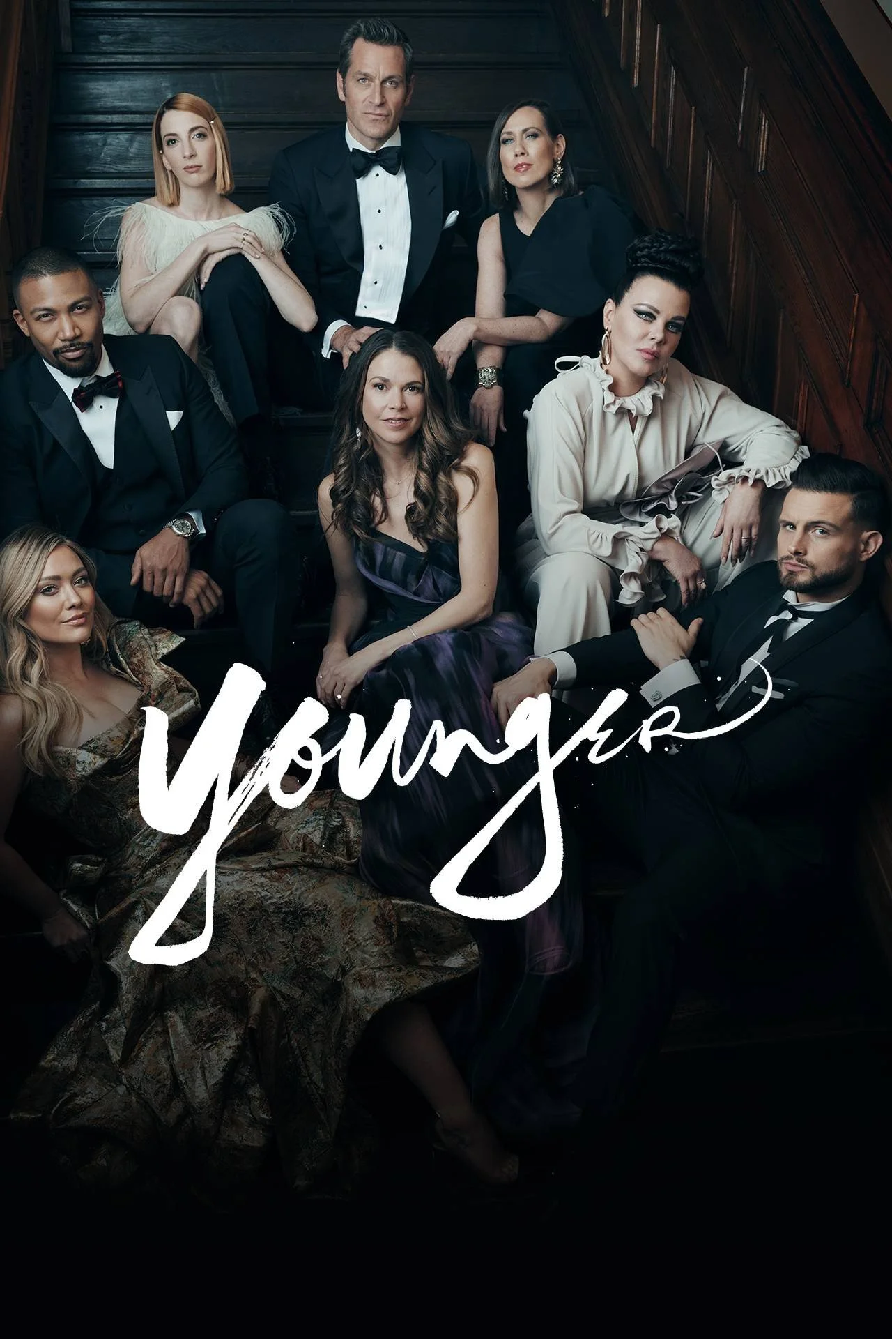 Group of six diverse people in formal attire sitting together on a staircase, with the word 'Young' written in large white script at the bottom.