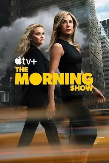 Two women walking in an urban setting with skyscrapers in the background, with smoke or fog behind them. The image promotes Apple TV+ TV show 'The Morning Show'.