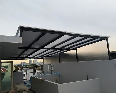 Construction site with a partially built rooftop structure, including a metal roof frame, ladder, and city skyline in the background.