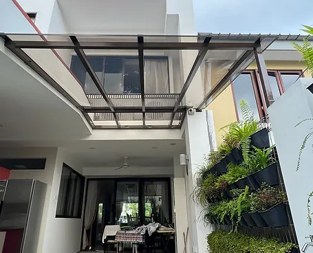 View of a modern house with a glass balcony and vertical garden on the exterior wall.