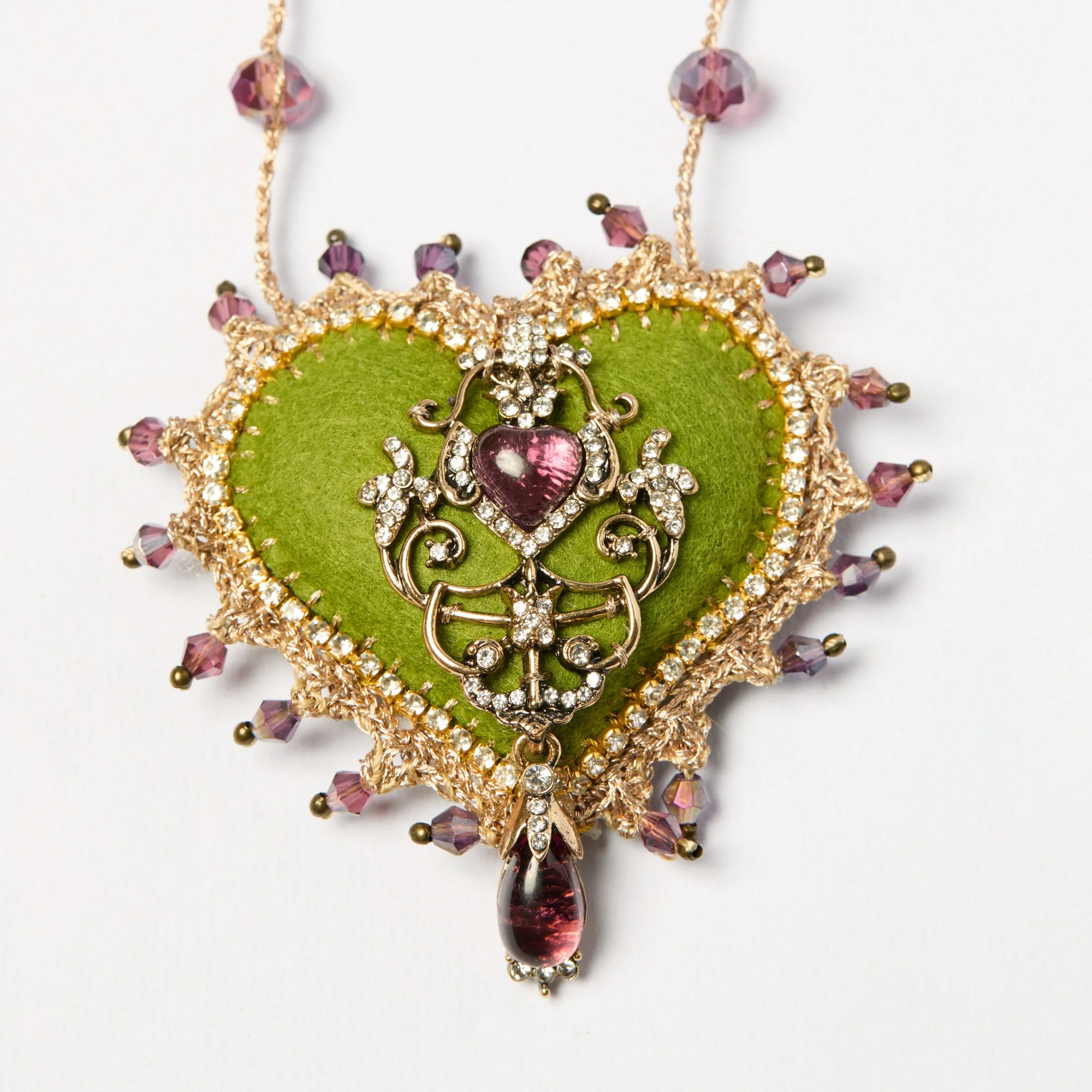 A decorative necklace with pink beads, rhinestones, and a large tear-drop shaped pink gemstone centerpiece on a white background.