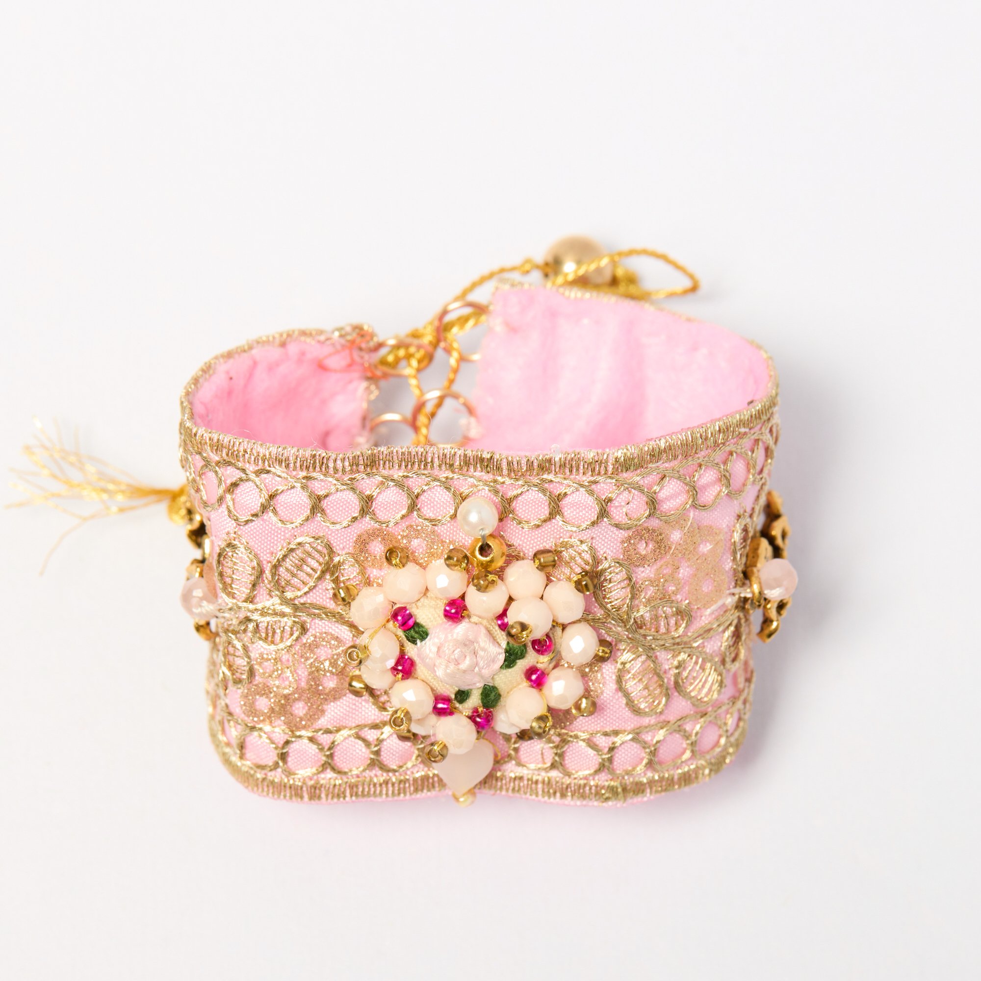 Close-up of a pink, gold, and pearl decorative jewelry box or container on a white background.
