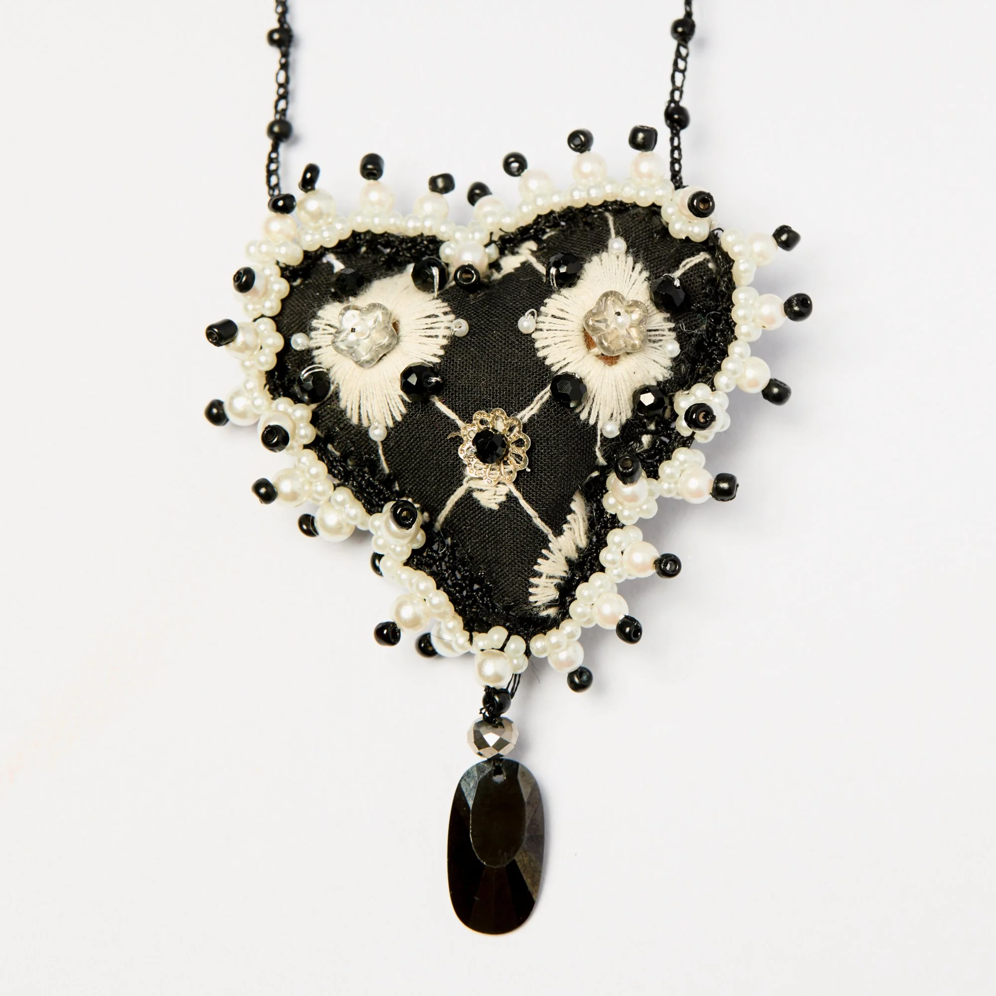 Black and white beaded necklace with floral and teardrop-shaped pendant