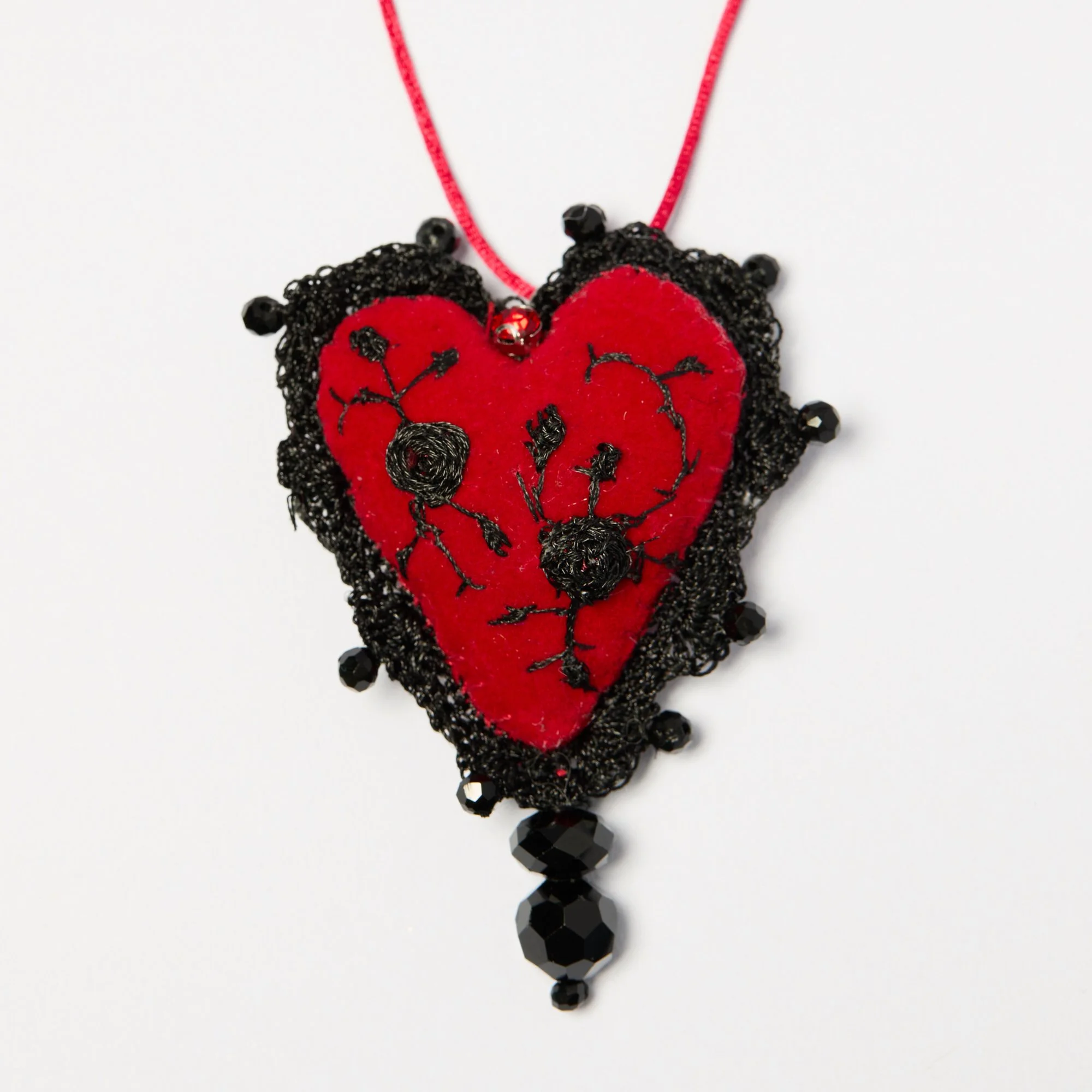 Black beaded necklace with a red heart-shaped pendant and black hanging beads
