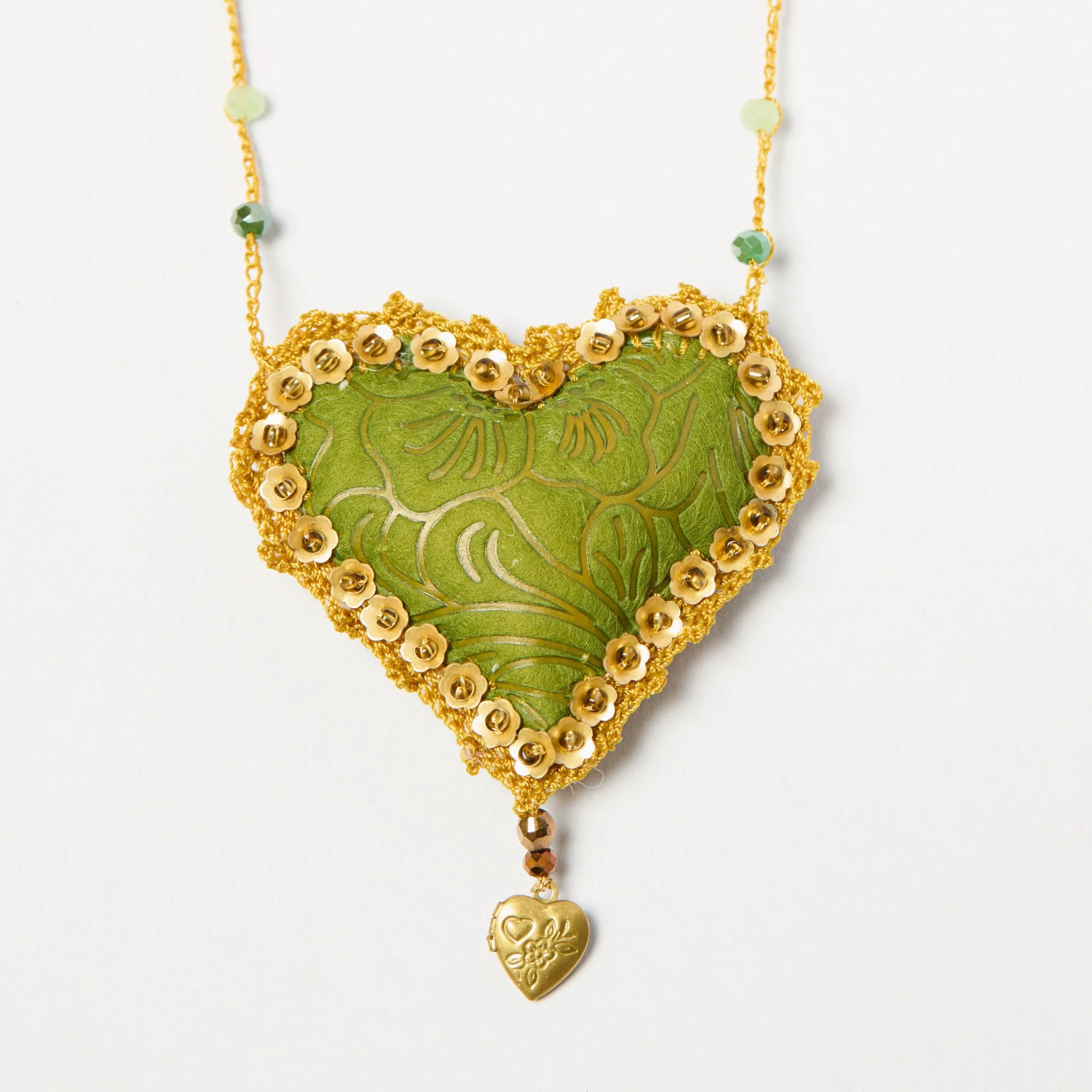 Gold and green decorative necklace featuring a gold heart charm engraved with flowers and the word "Love" and adorned with small flower embellishments.