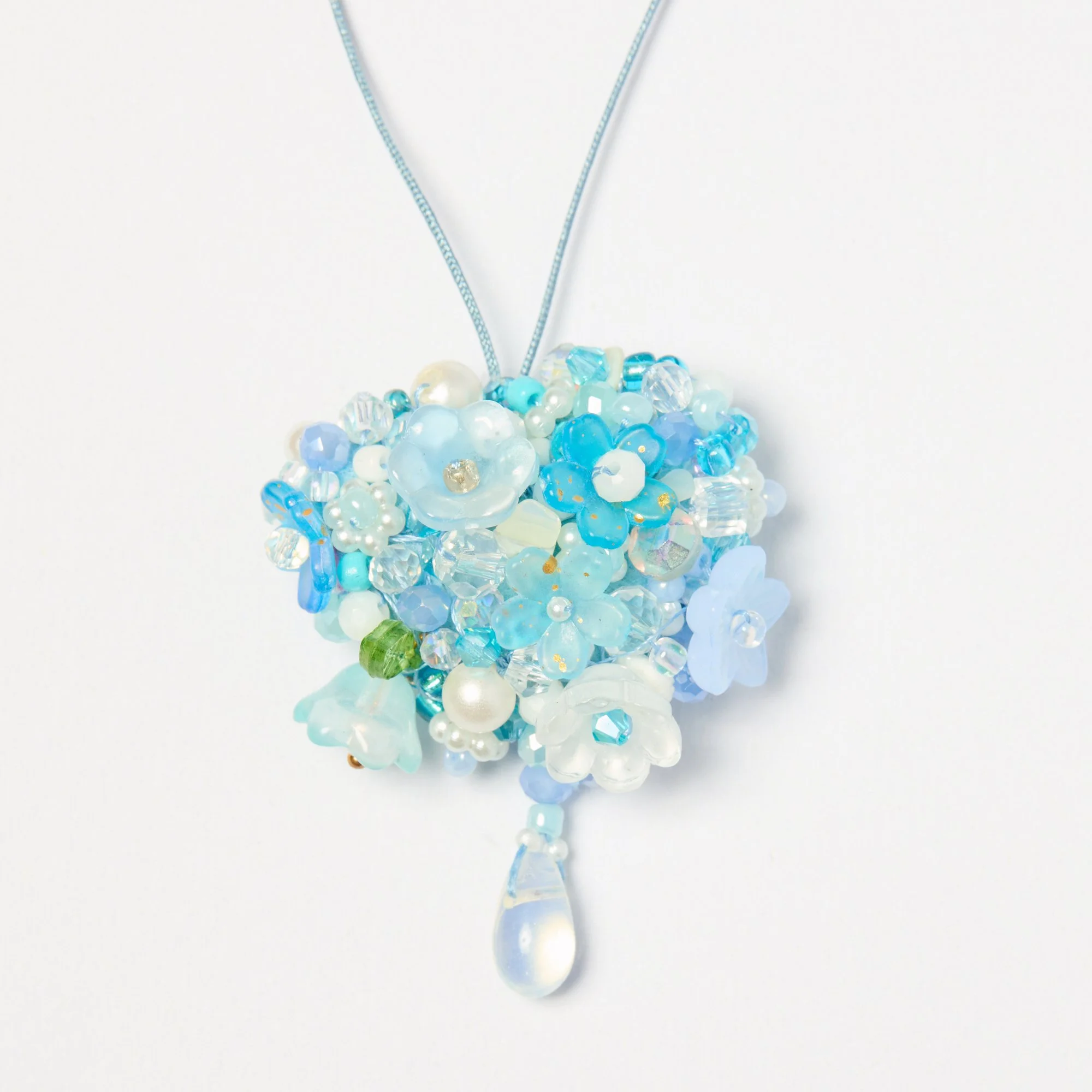 A necklace made of blue and white beads with a teardrop-shaped pendant hanging from a string of smaller beads.