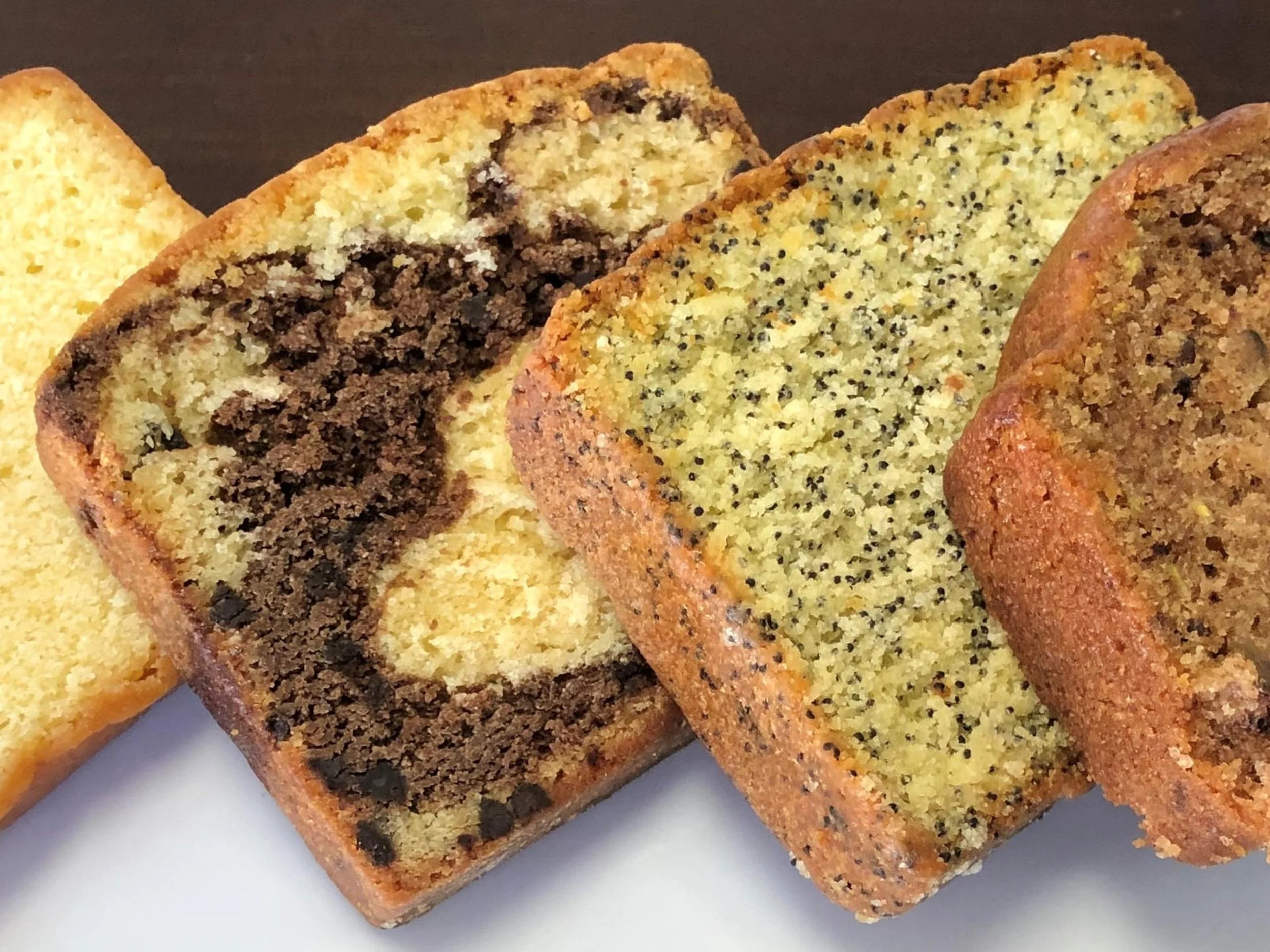 Slices of yellow cake with different flavors, including chocolate, vanilla, and poppy seed.