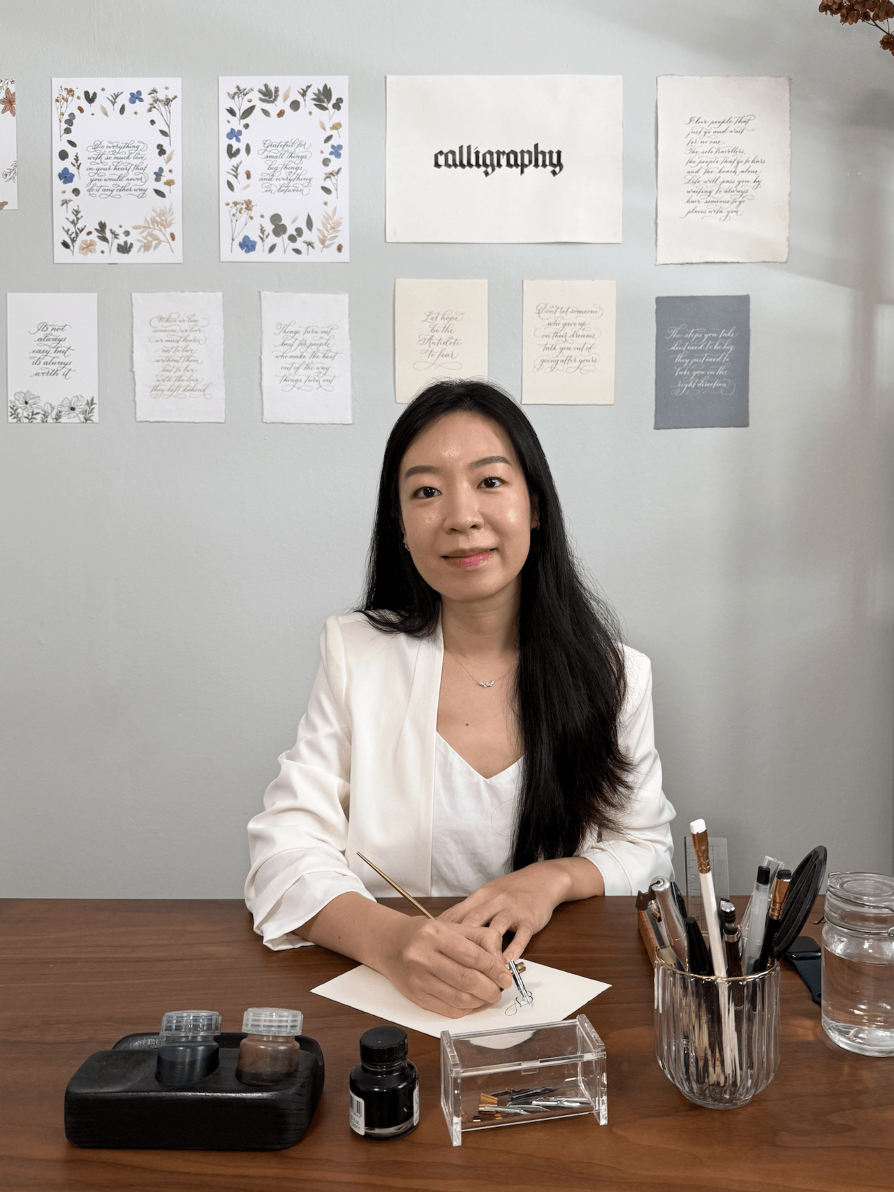 Verniecia Wong, calligrapher and founder of The Letter V Studio in Singapore, writing with a dip pen at her desk