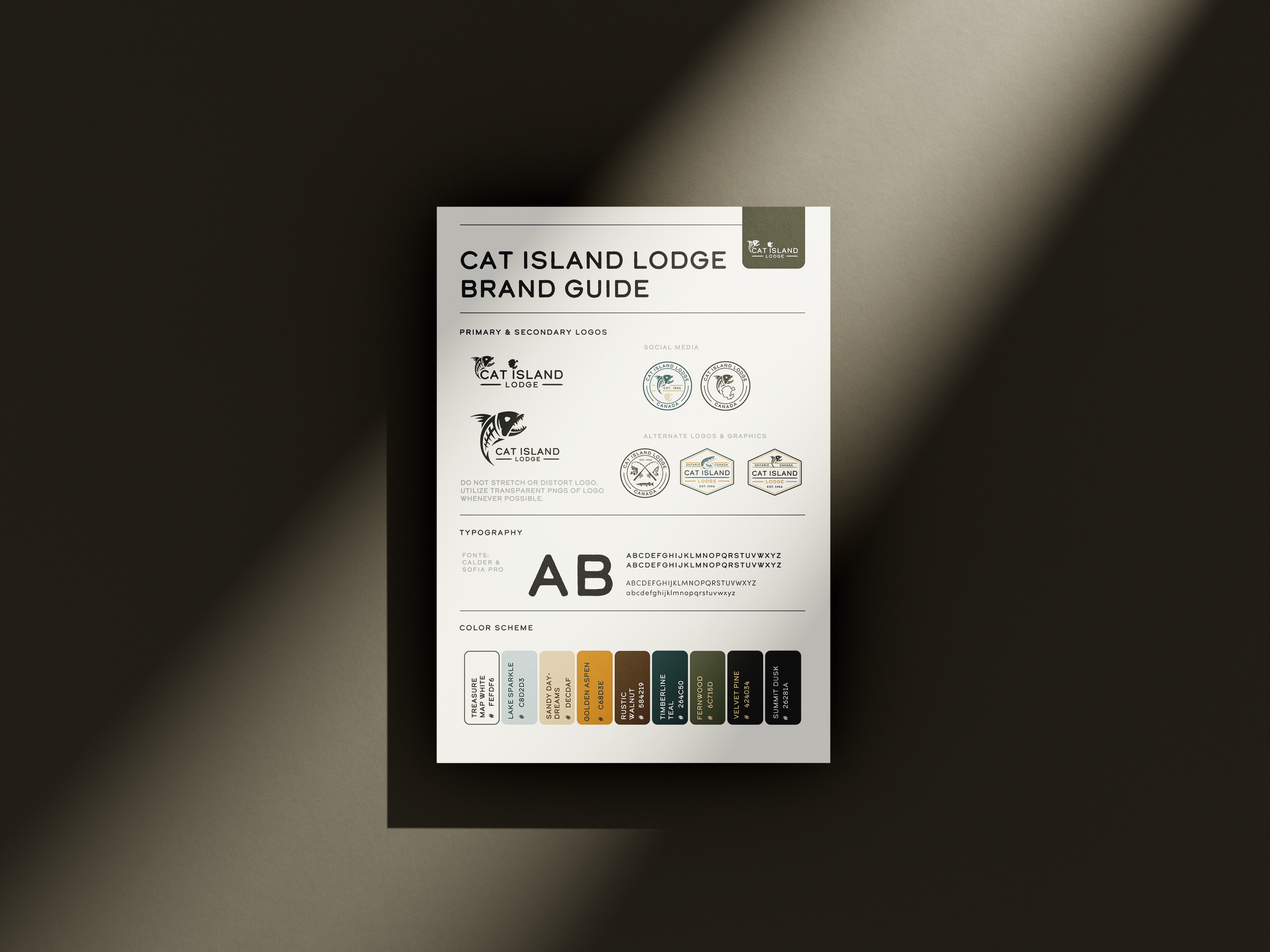 A brand guide sheet for Cat Island Lodge showing logos, typography, and color scheme on a white paper placed on a beige surface with shadows.