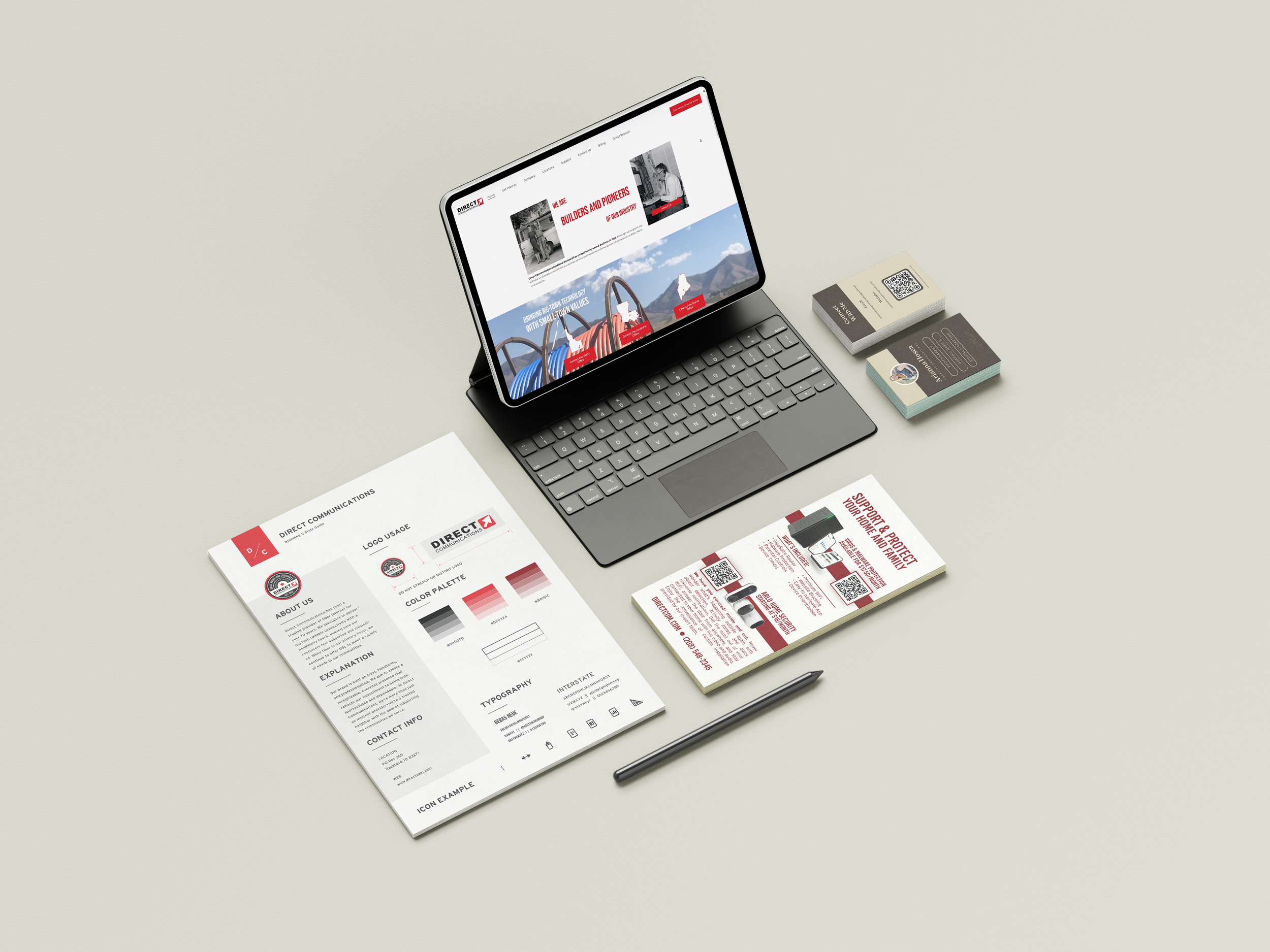 Flat lay of a workspace with a tablet displaying a website, a pen, printed brochures, business cards, and a sheet of paper with branding guidelines on a light surface.