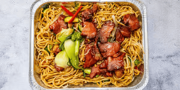 Takeout container filled with stir-fried noodles, sliced beef, broccoli, and red bell pepper slices.
