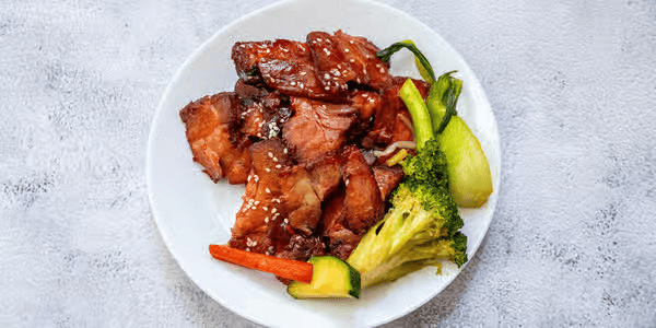 Plate of glazed beef with broccoli, carrots, and zucchini