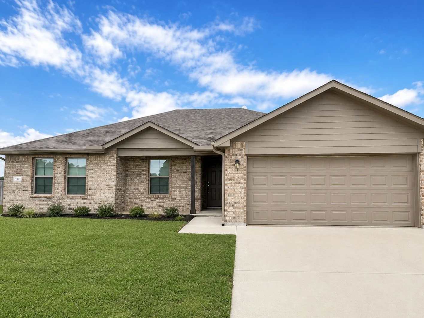 A single-family house for rent with brick and siding exterior, a two-car garage, managed by Real Hope Properties.