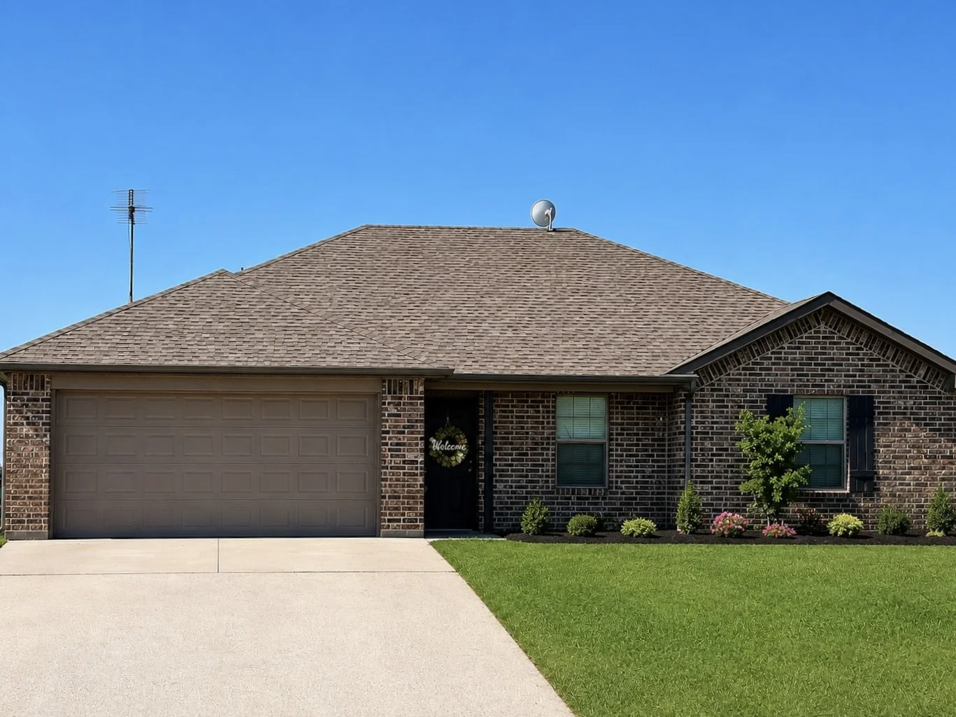 A single-family house for rent with brick and siding exterior, a two-car garage, managed by Real Hope Properties.
