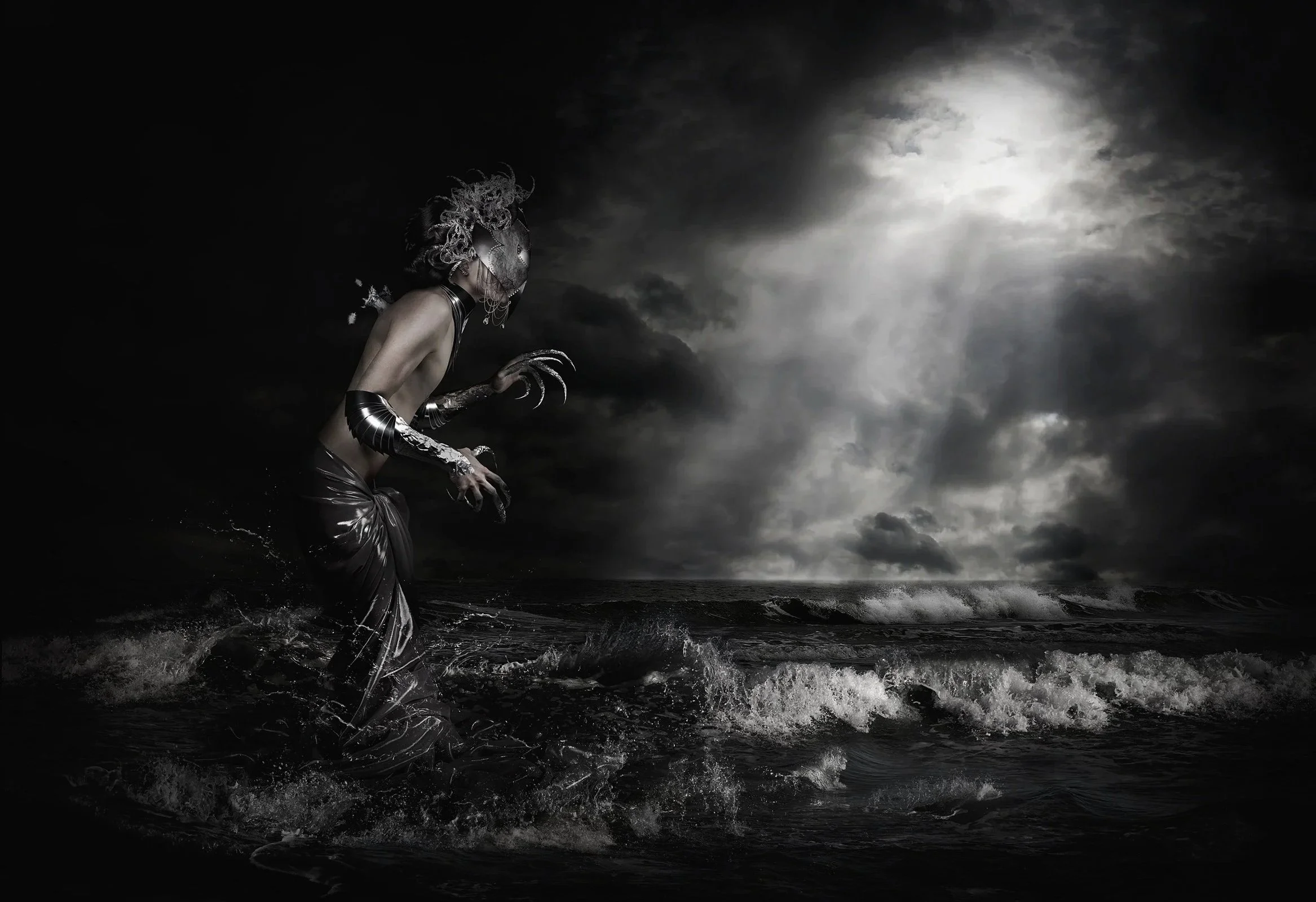 Femme avec un masque de carnaval, costume en latex, tenant une main en forme de claw, marchant sur la plage sous un ciel orageux et nuageux avec la pleine lune visible.