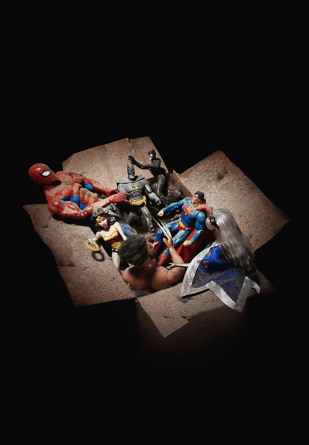 Figurines de super-héros et un personnage ressemblant à Jésus dans un décor de terrain, avec des personnages de Batman, Wonder Woman, Superman, Spider-Man et un homme avec des cheveux gris et des lunettes.