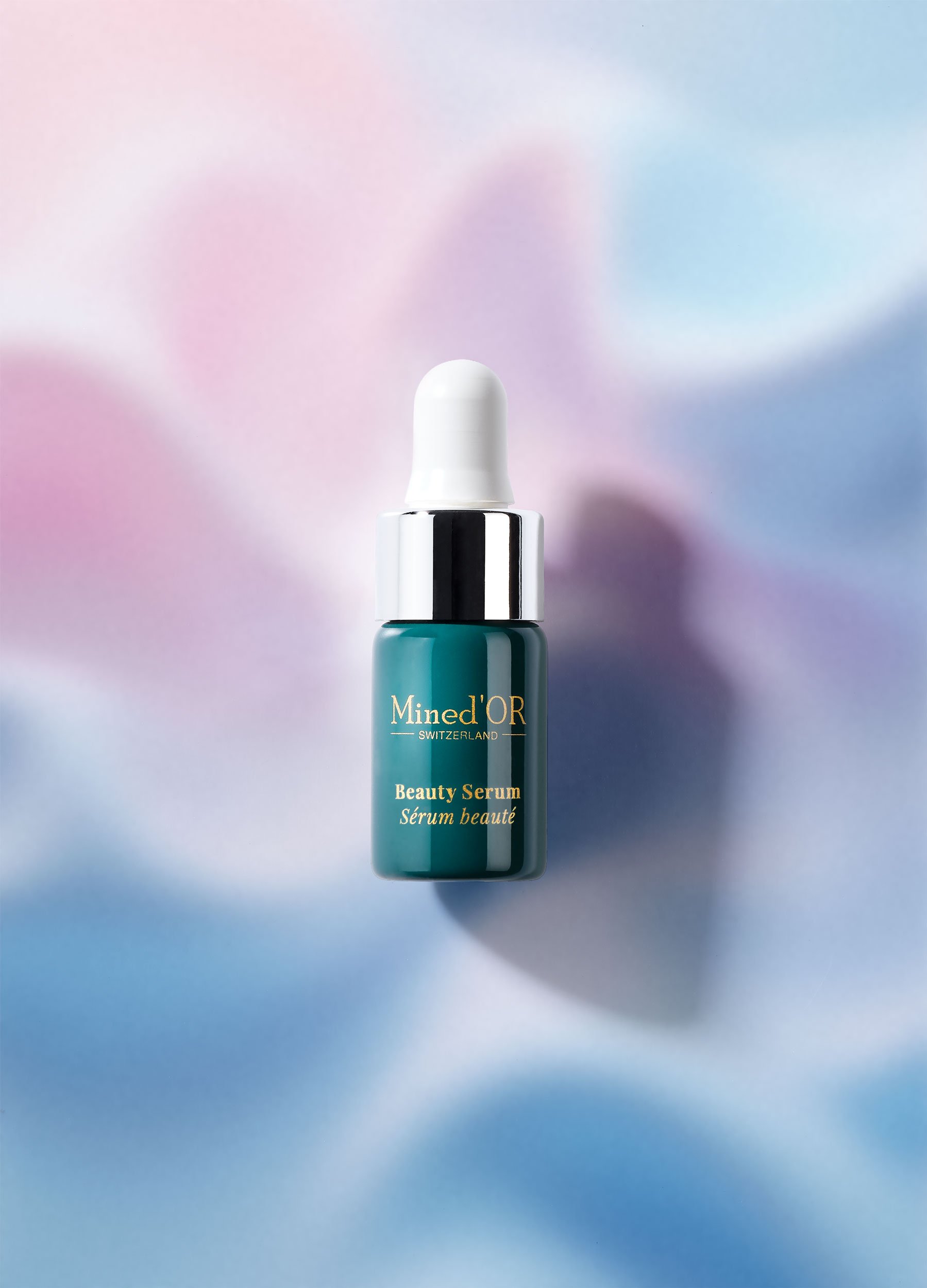 Flacon de sérum de beauté vert avec bouchon blanc, marquages dorés, fond pastel flou