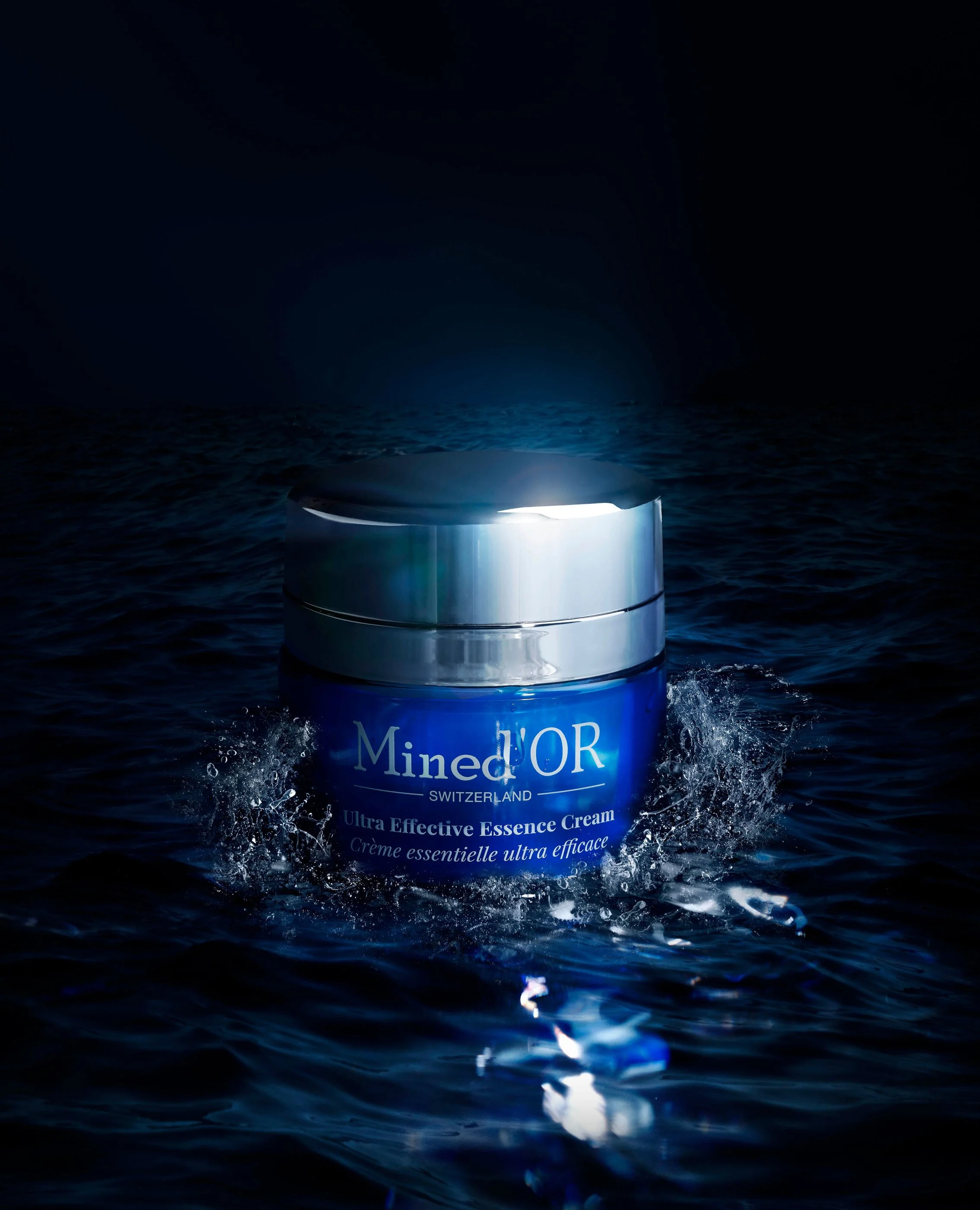 Un pot de crème Mined
d'OR posé sur l'eau avec des éclaboussures, sous un ciel nocturne, en train de flotter ou d'être lancé dans la mer.