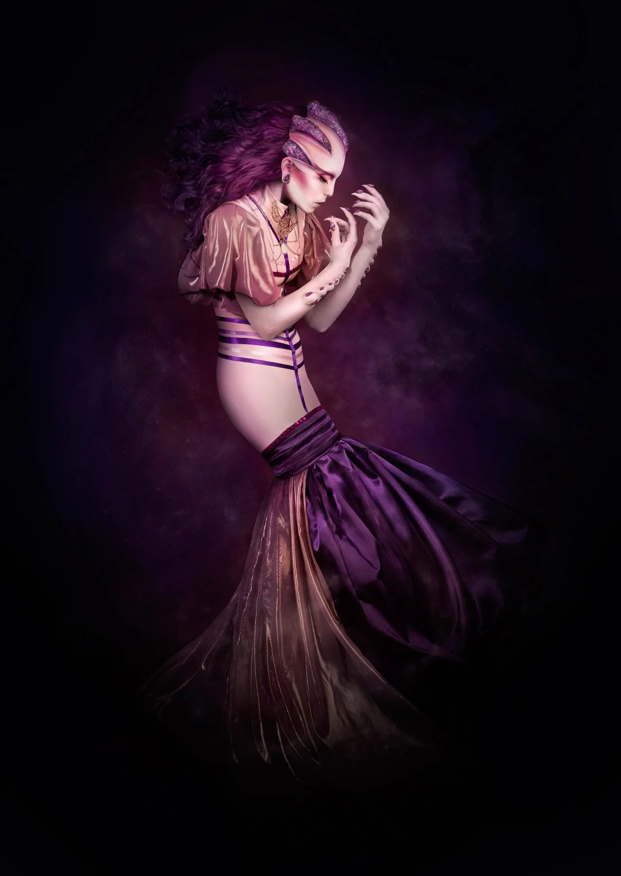 Femme déguisée en sirène avec longue robe violette, cheveux bouclés violet foncé, décor fantastique avec nuages ou poussière magique violette