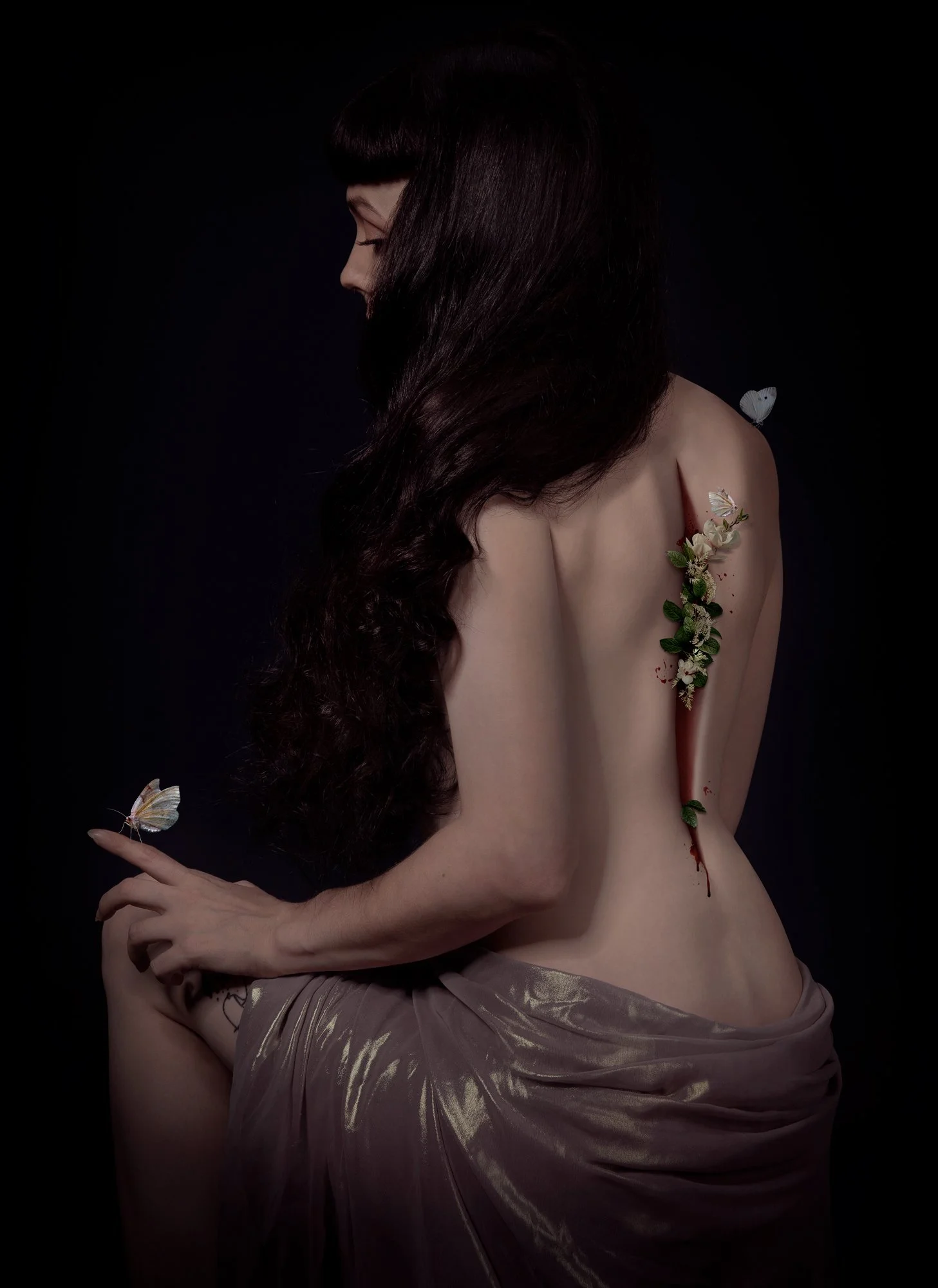 Une femme nue vue de côté avec de longs cheveux bruns foncés, un côté du visage est visible, les yeux fermés et une expression calme. Elle a une cicatrice avec des fleurs et du sang sur l'épaule droite, et une fourmi repose sur son bras. Deux papillo
