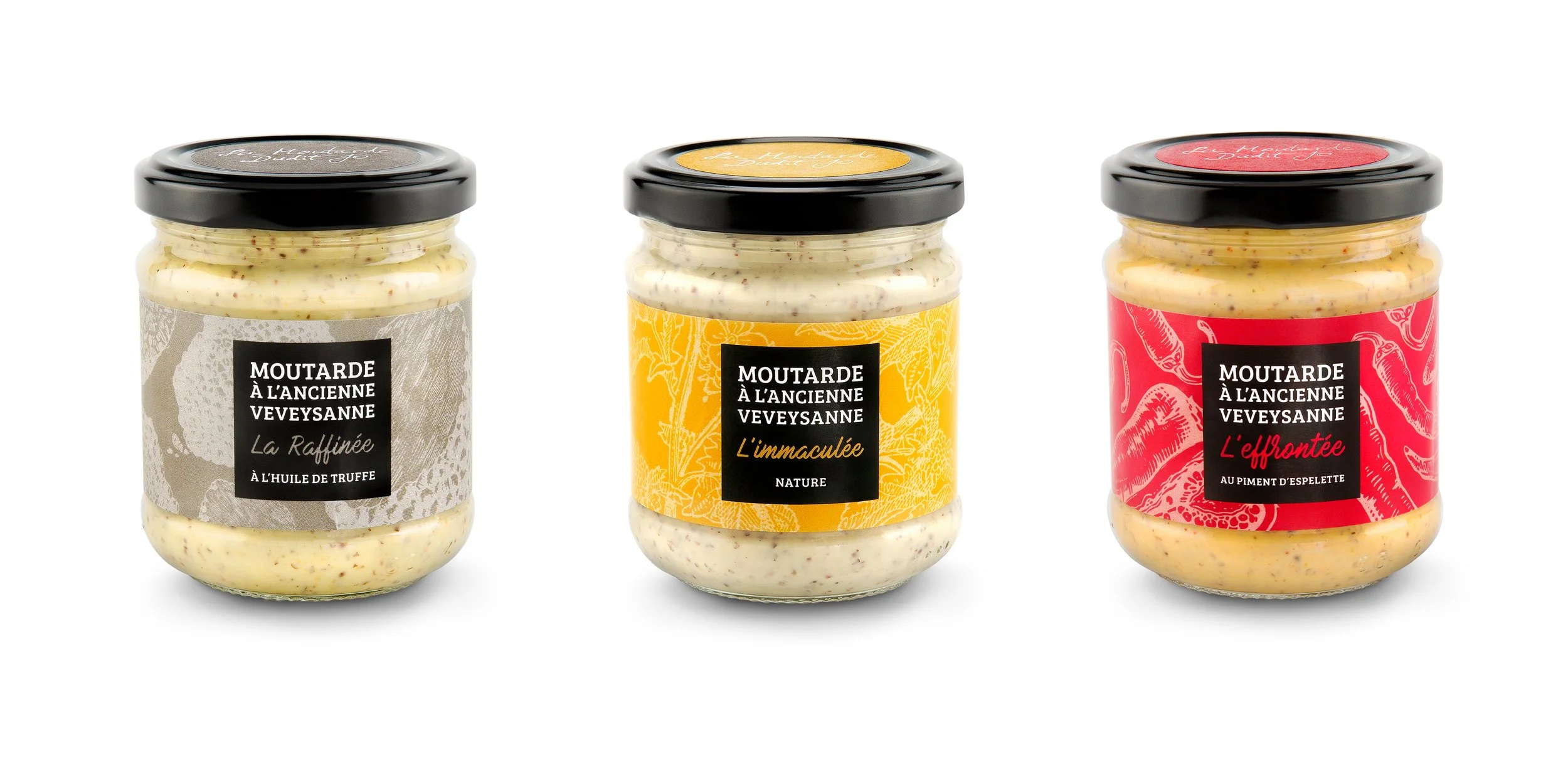 Trois pots de moutarde de la marque Veveysanne, chacun avec une étiquette différente : La Raffinée, L'immmaculée et L'effrontée, dans des couleurs neutres, jaunes et rouges respectivement.