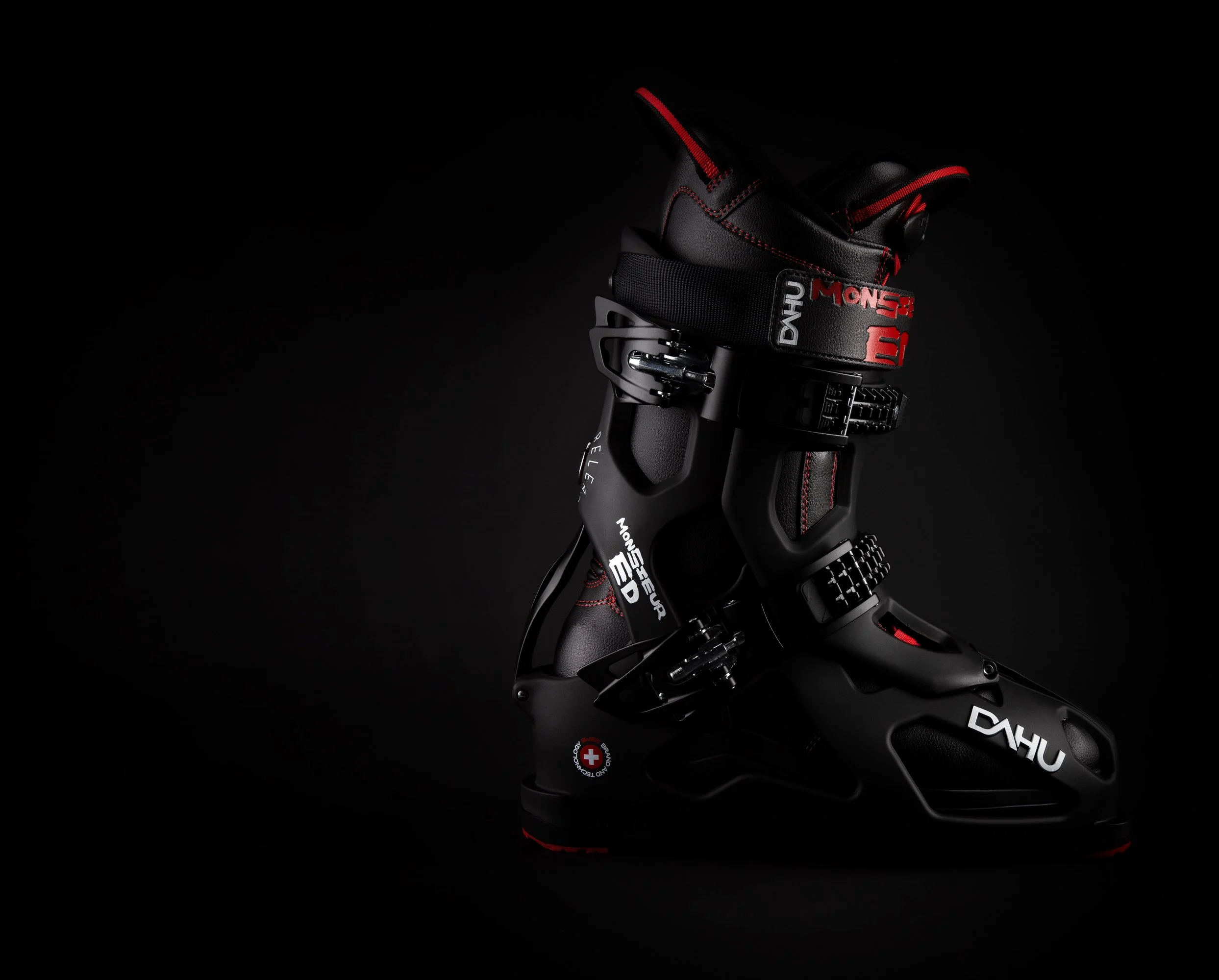 Une chaussure de ski alpin noire avec des détails rouges, marquée du nom 'Dahu'.