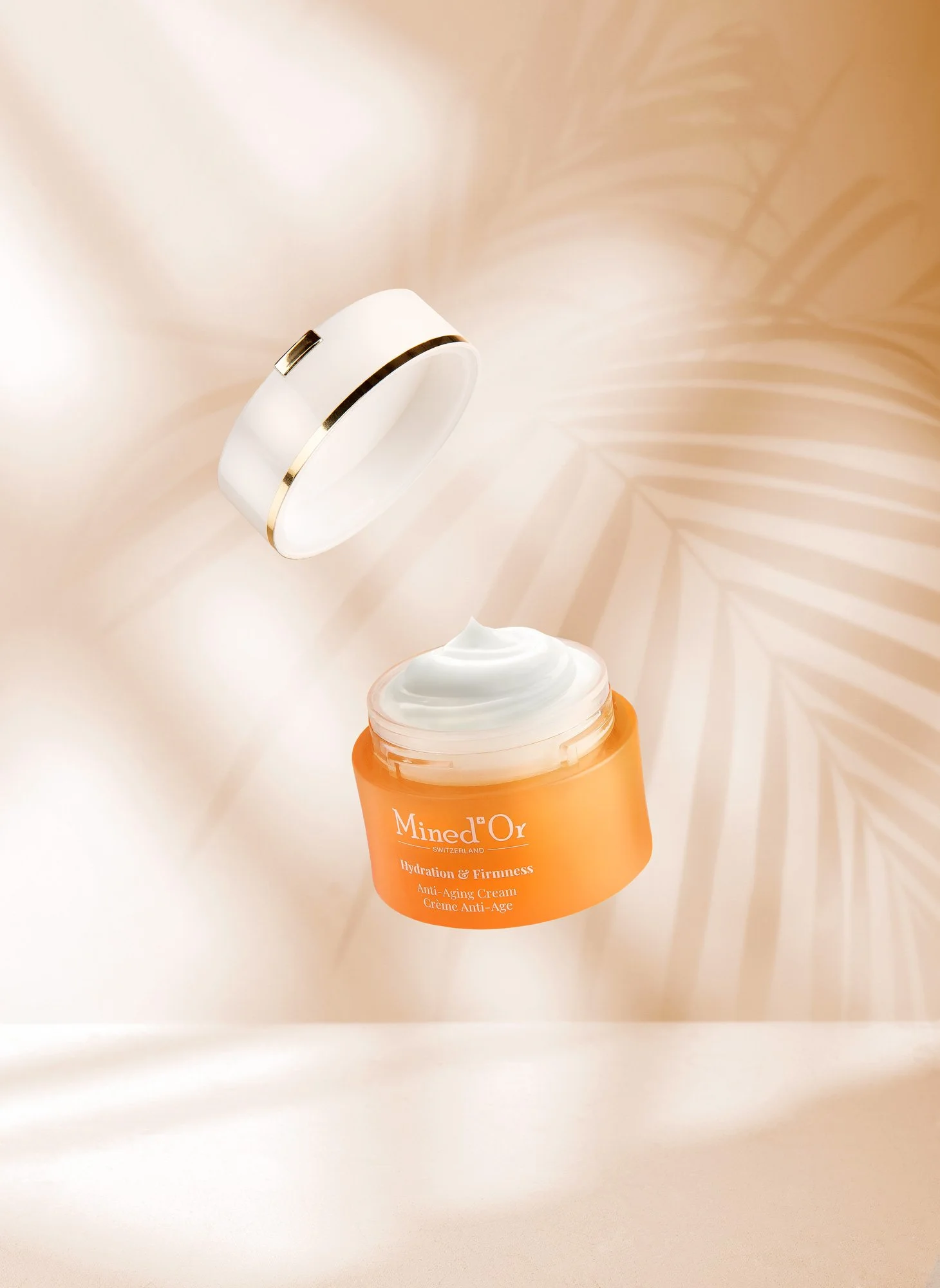 Crème anti-âge Mined'O², hydratation et fermeté, flacon orange avec texte blanc, crème blanche visible dans le pot