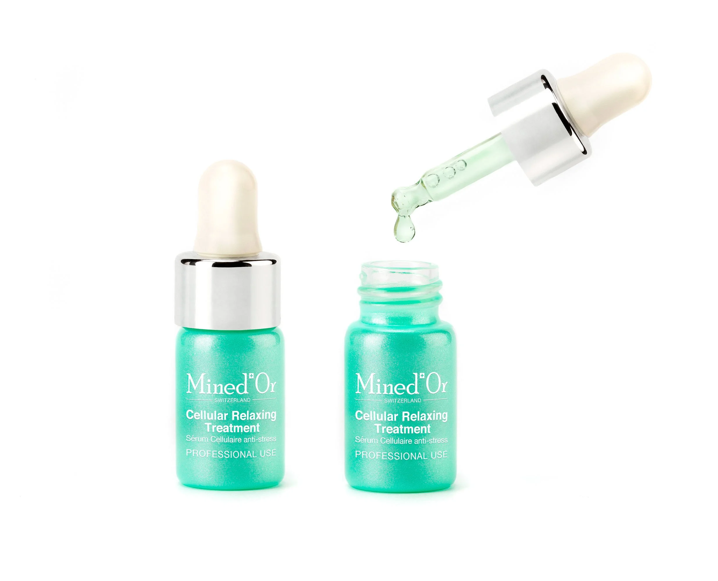 Deux flacons de sérum de traitement anti-stress de couleur vert mint avec bouchons blancs, l'un avec le bouchon retiré et une goutte tombant, sur fond blanc.