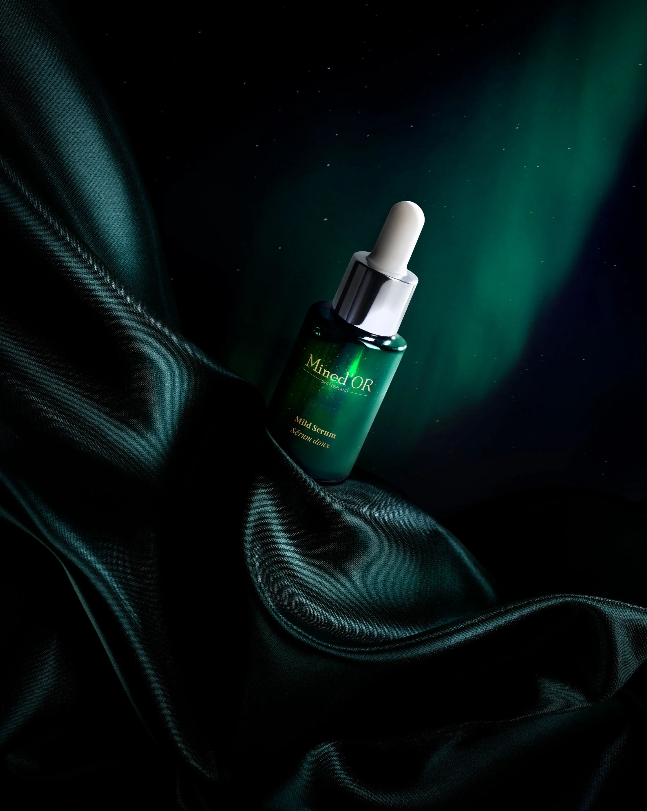 Serum dans un flacon vert avec pipette, posé sur un tissu en satin noir, avec une lumière verte en arrière-plan.