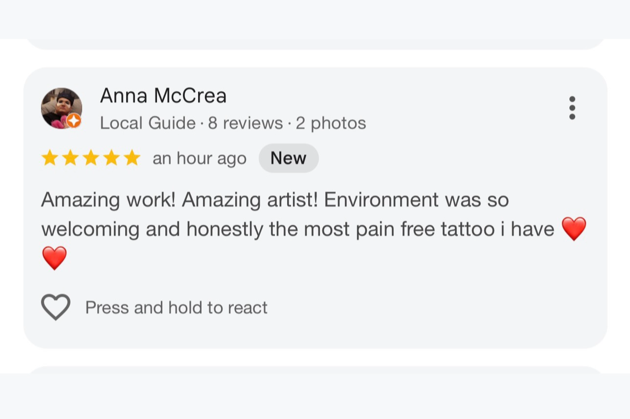 A screenshot of a positive review for a tattoo artist named Anna McCrea, praising the environment and her work, with a five-star rating and heart emojis.