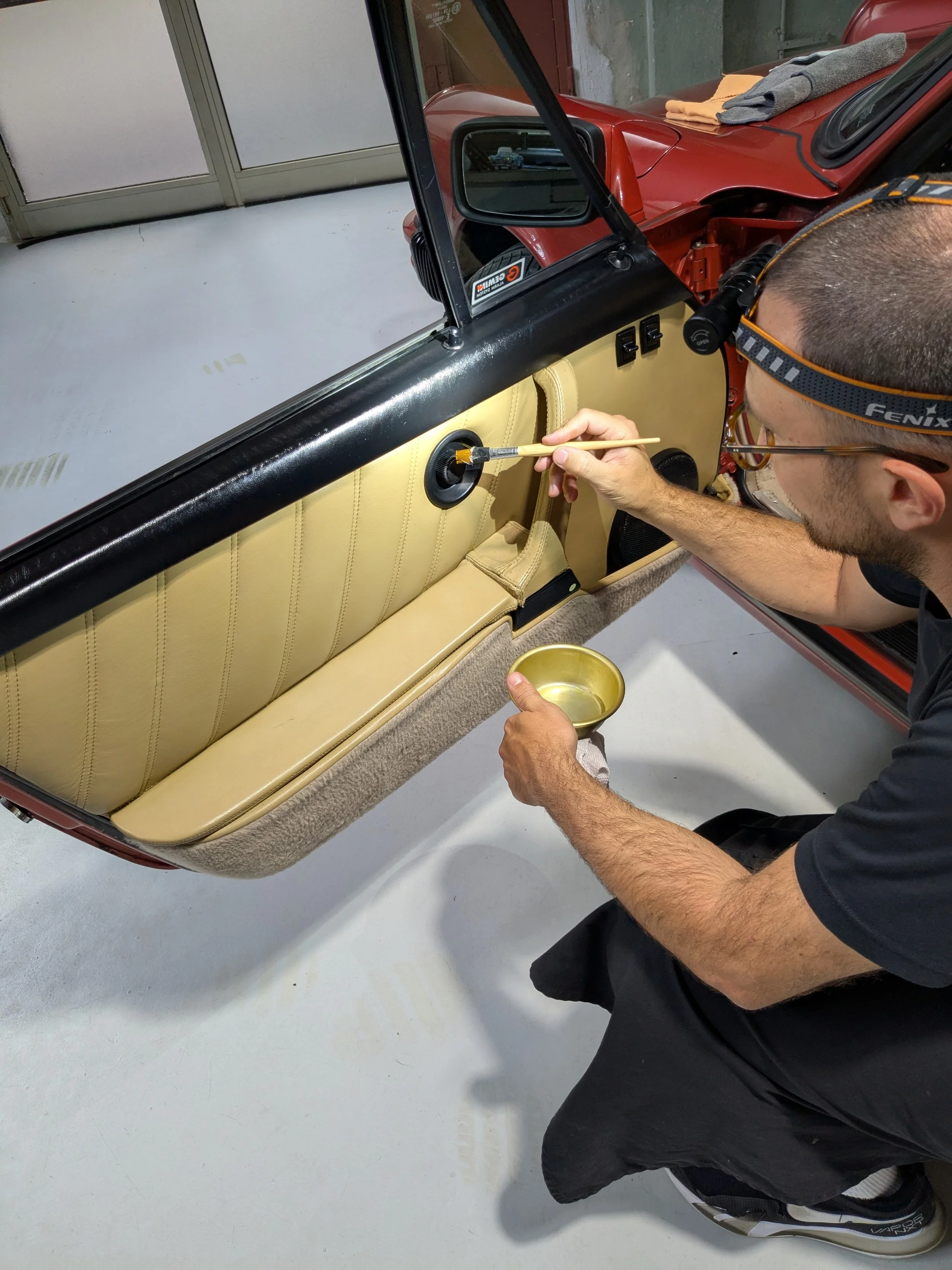 Aesthetic restoration of a classic car interior door panel by Ilario Schiattarella during a detailing treatment preserving original materials.