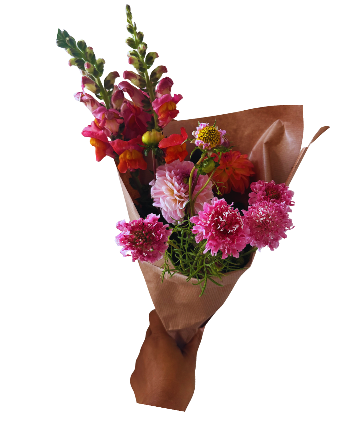 Hand holding a bouquet of pink, red, and orange flowers wrapped in brown paper.