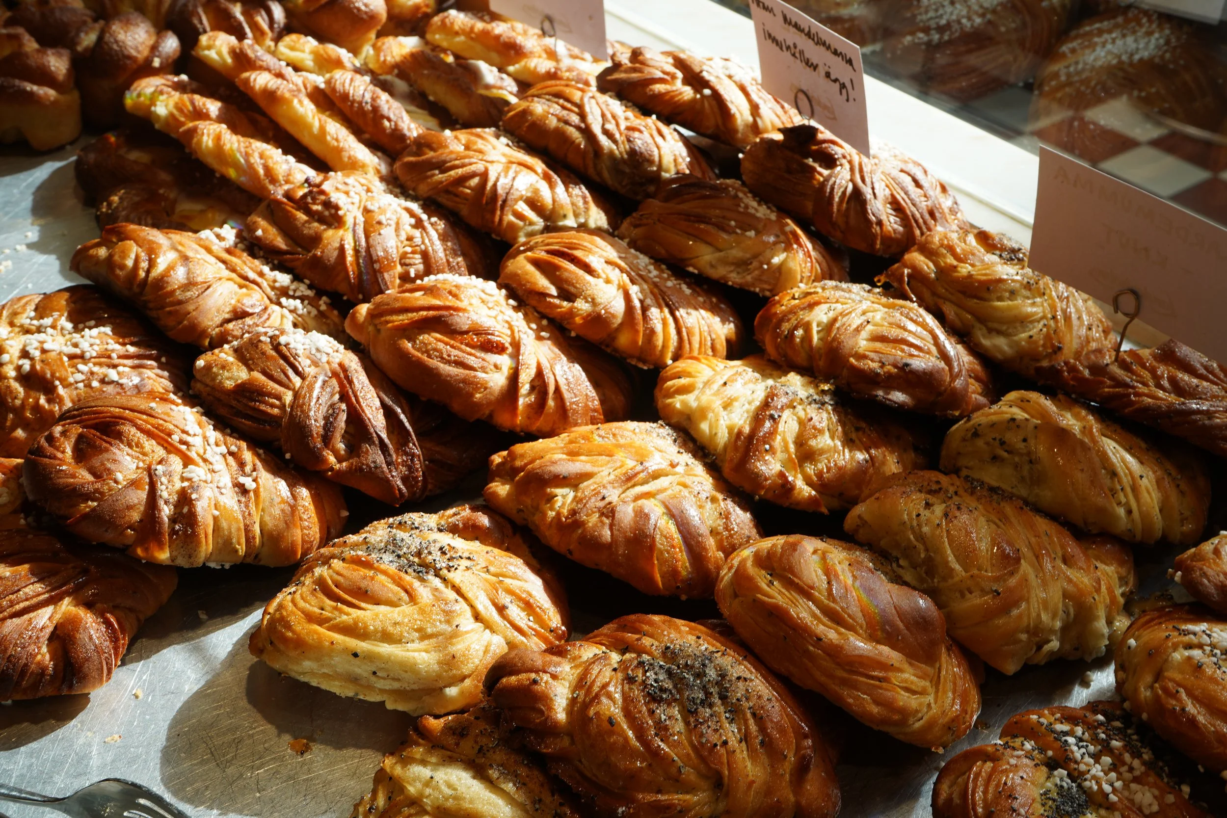 Färska bakverk, inklusive croissanter och andra sorters bullar, på en bakbänk.