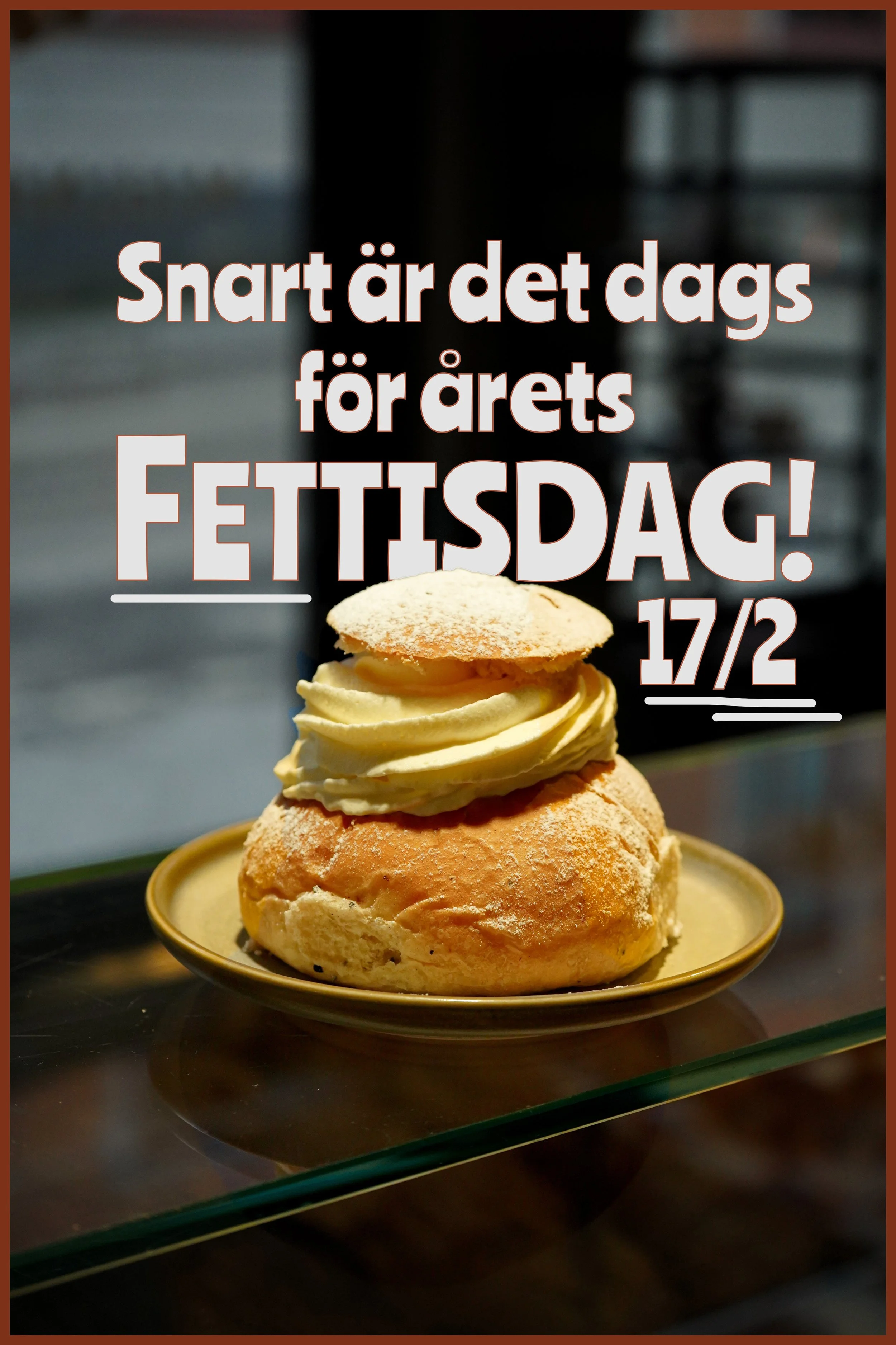 En bakelse med spritsad fyllning och ett pudrat kaksmakko, serverad på en guldfärgad tallrik.