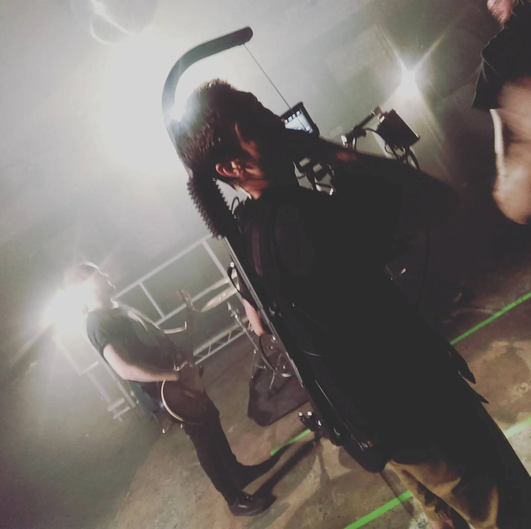 A person holding a camera and filming a music video.