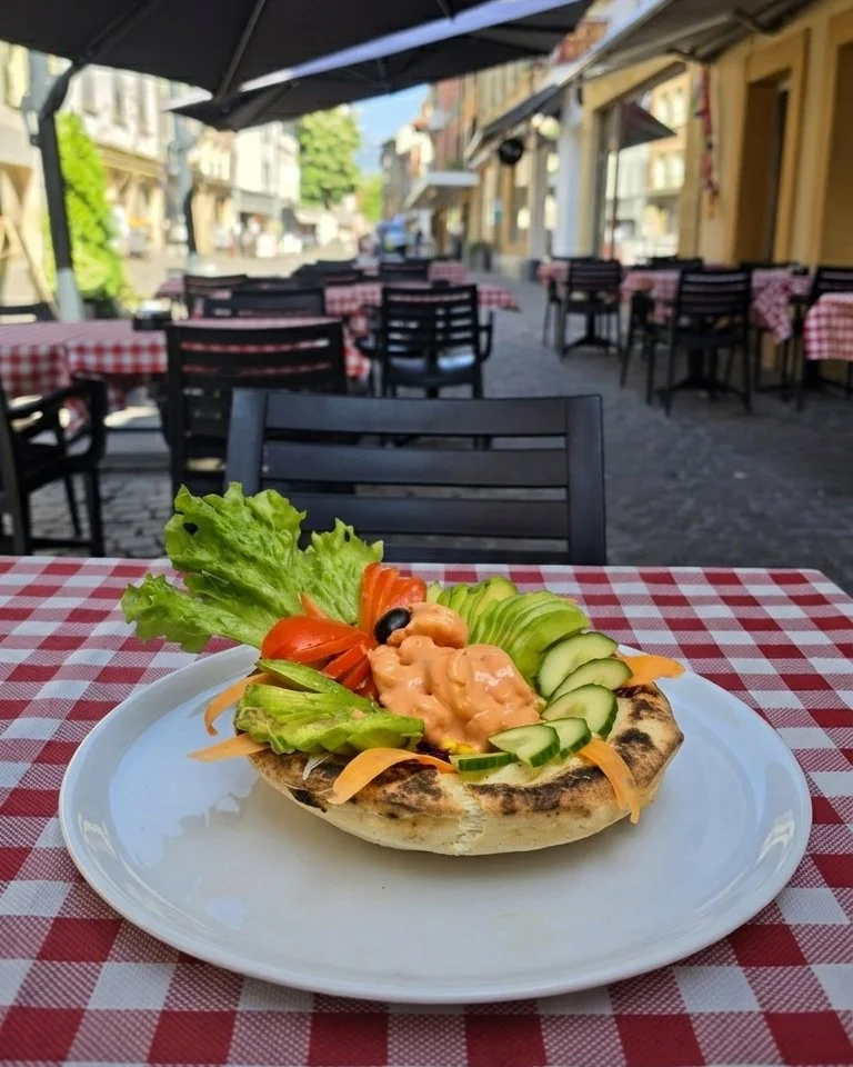 Ein köstlicher Salat mit Rohschinken, Toasts mit warmem Ziegenkäse und Rohkost, serviert auf der Terrasse im Bellucci in Yverdon-les-Bains