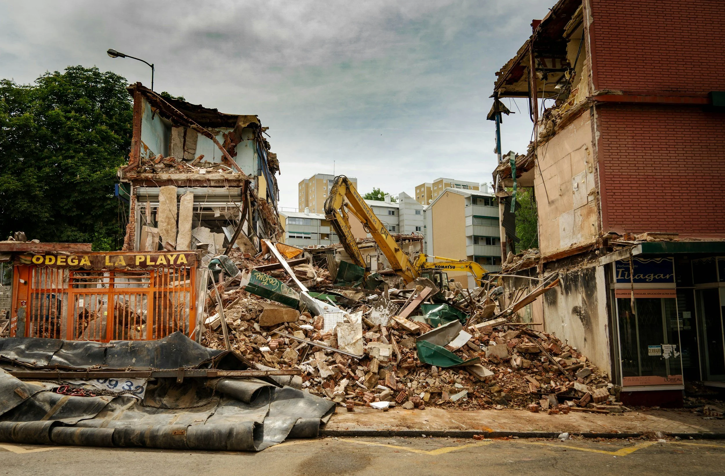 pile of rubble with a heavy machinery cleaning up