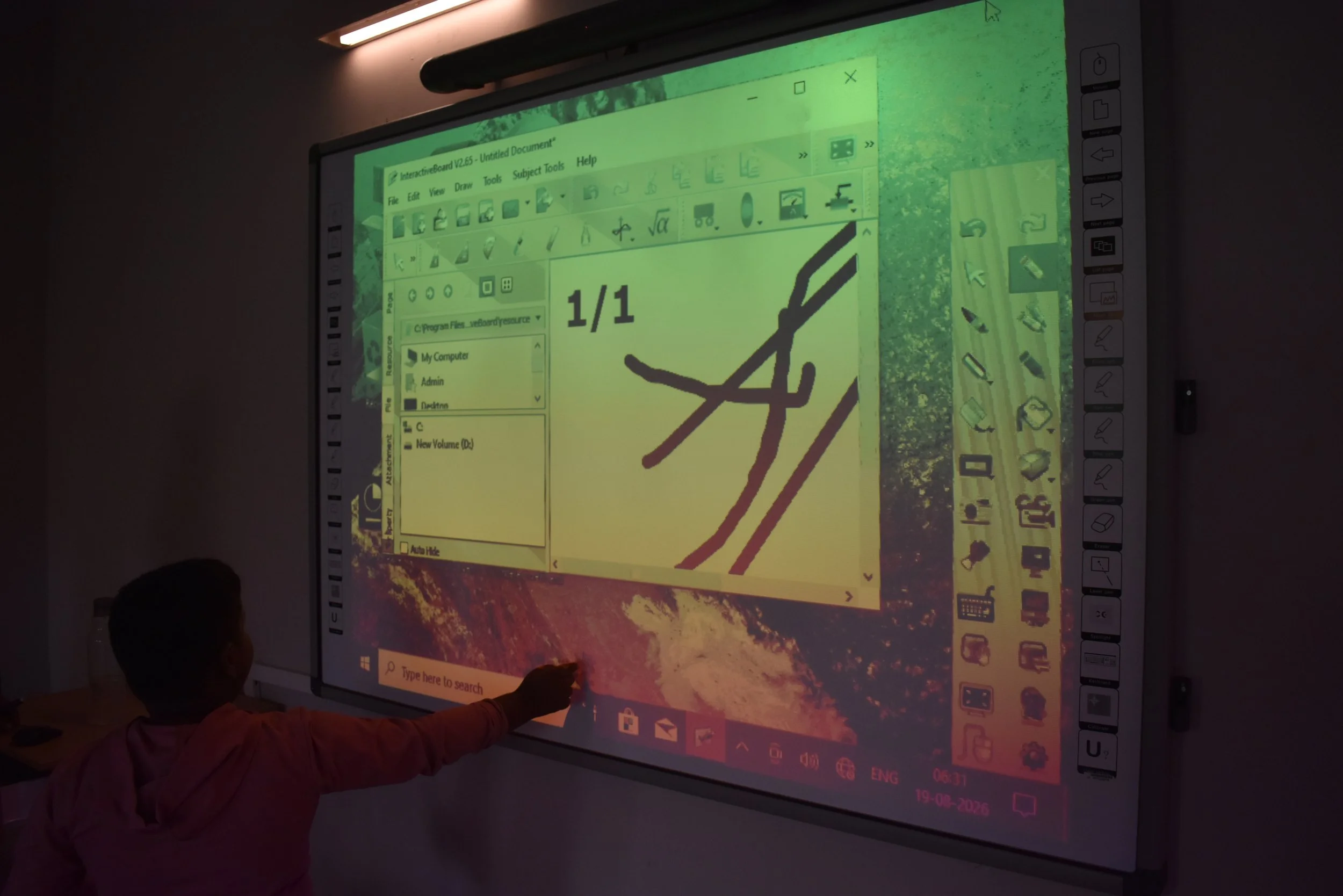 Child working at an interactive wall board in the classroom