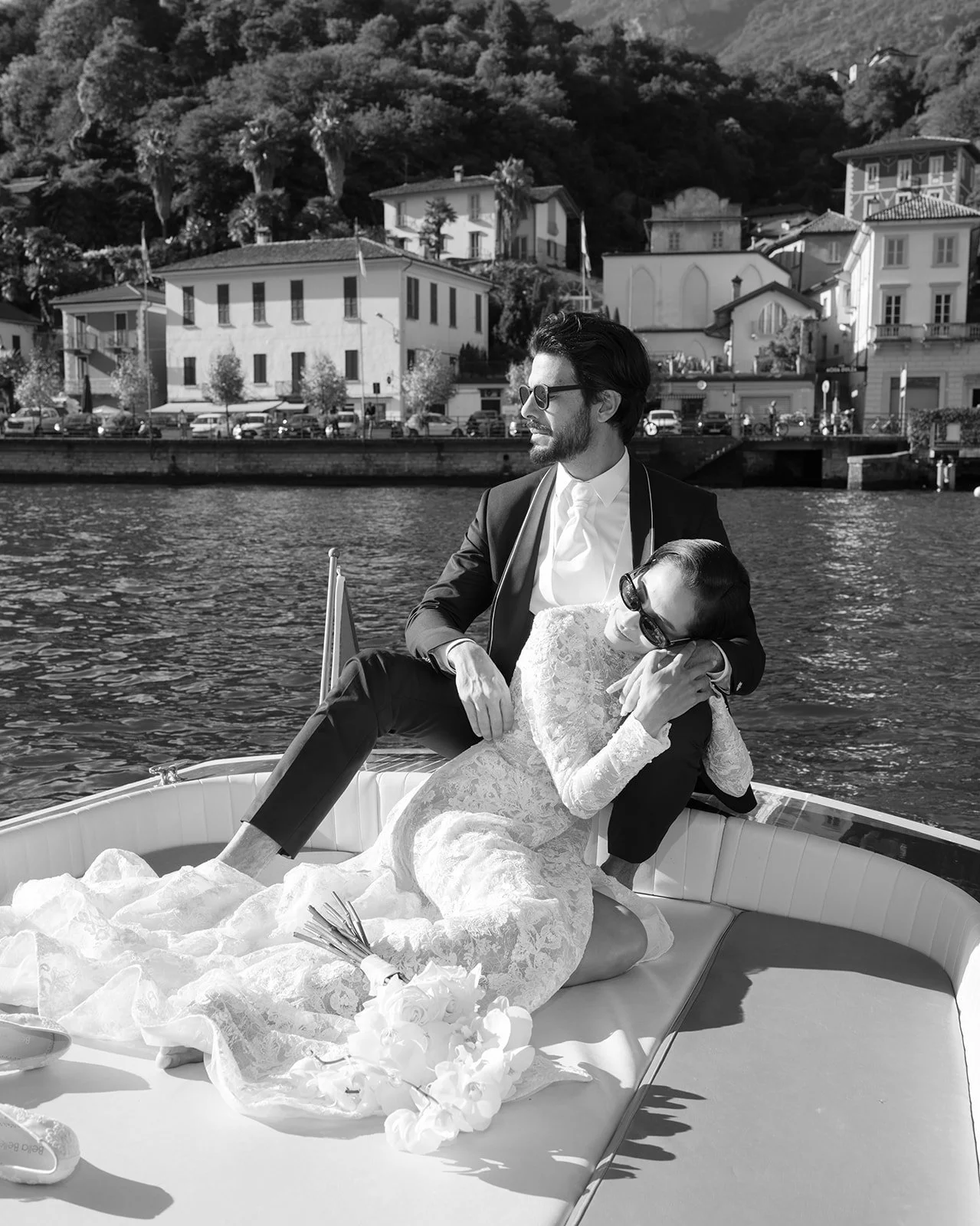 Black-and-white portrait of a bride and groom aboard a boat on Lake Como near Grand Hotel Tremezzo.