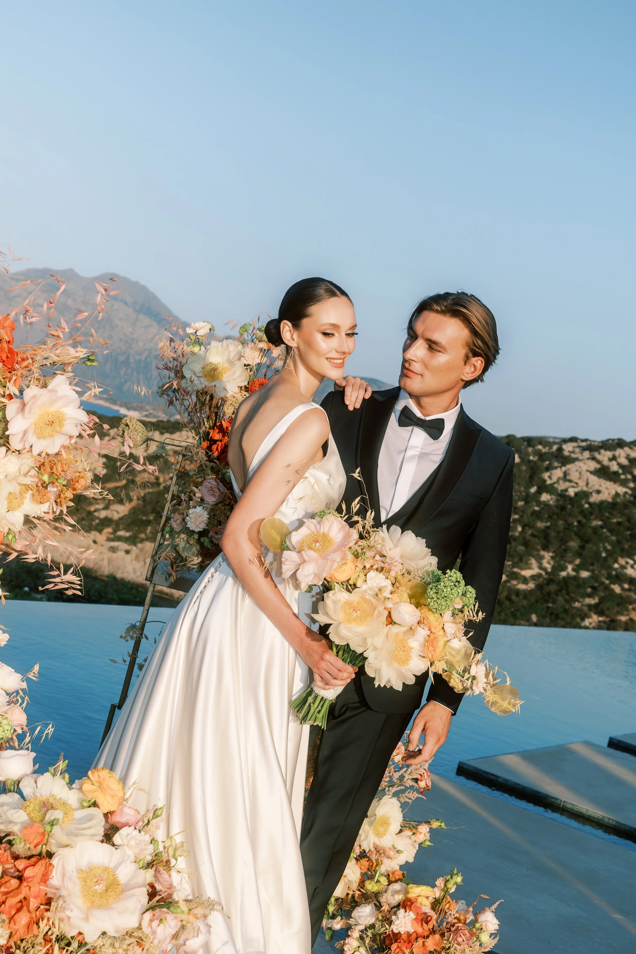 Bride and groom surrounded by organic florals during a private estate wedding ceremony in Crete.