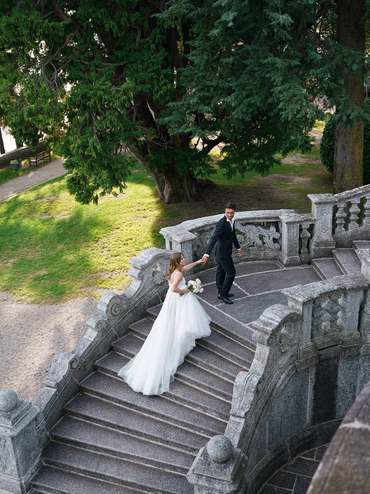 Couple walking together on an ornate stone staircase during an intimate garden elopement on Lake Como.