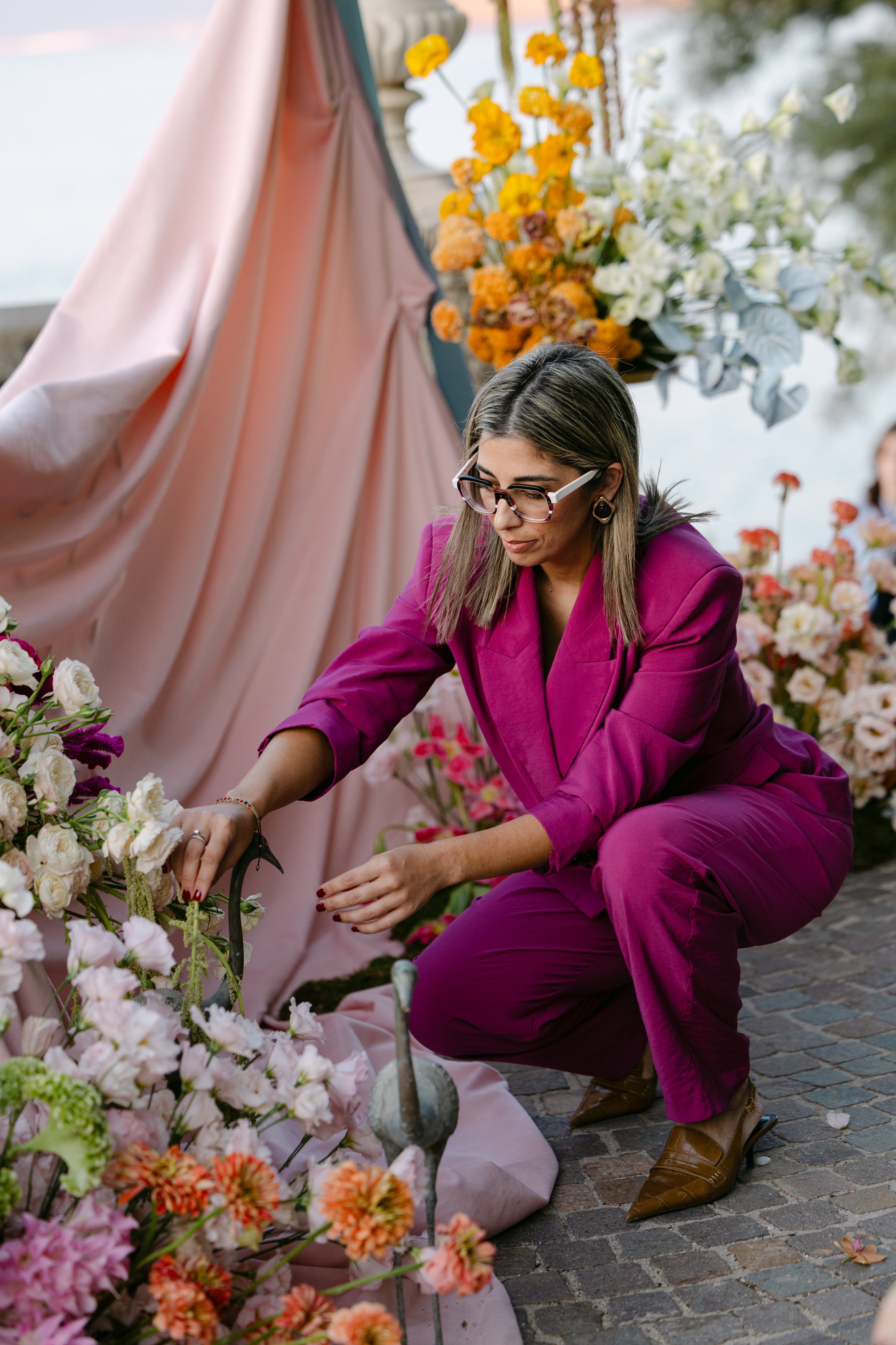 Chrysa, founder of HollyWed Events, arranging wedding flowers