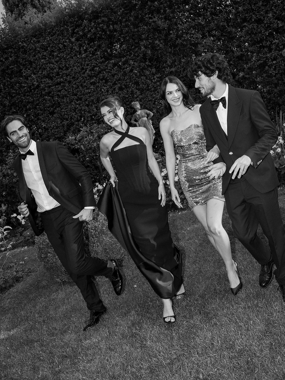Wedding guests celebrating in the gardens during an evening editorial at Villa Balbiano.