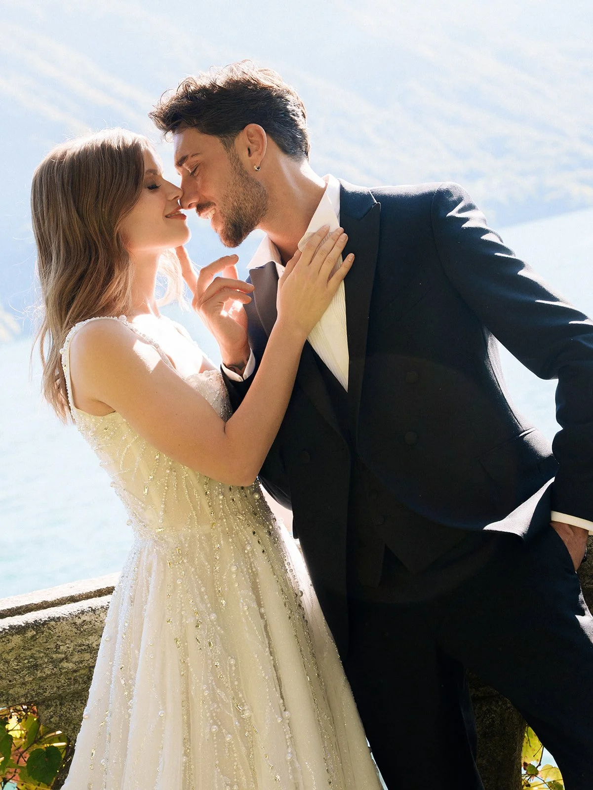 Couple standing closely together beside Lake Como during an intimate garden elopement.