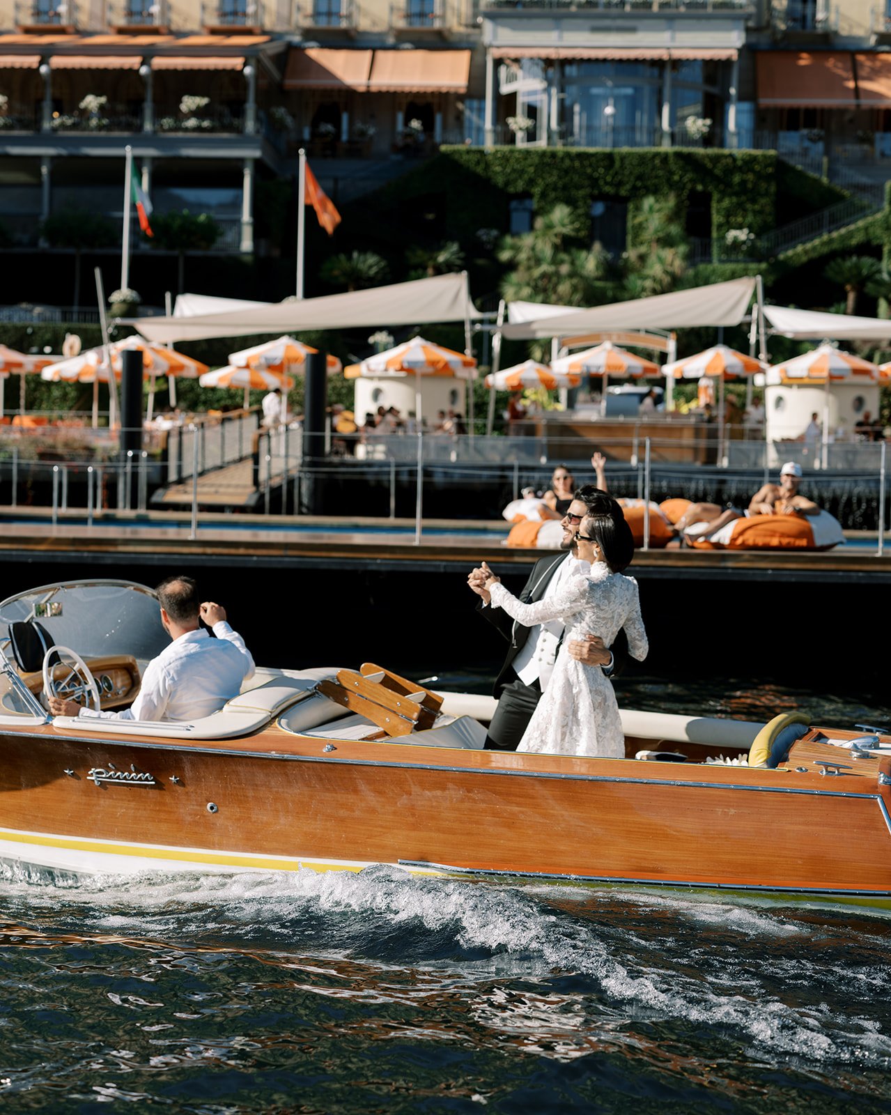 Bride and groom kissing aboard a vintage boat during a Grand Hotel Tremezzo wedding story.
