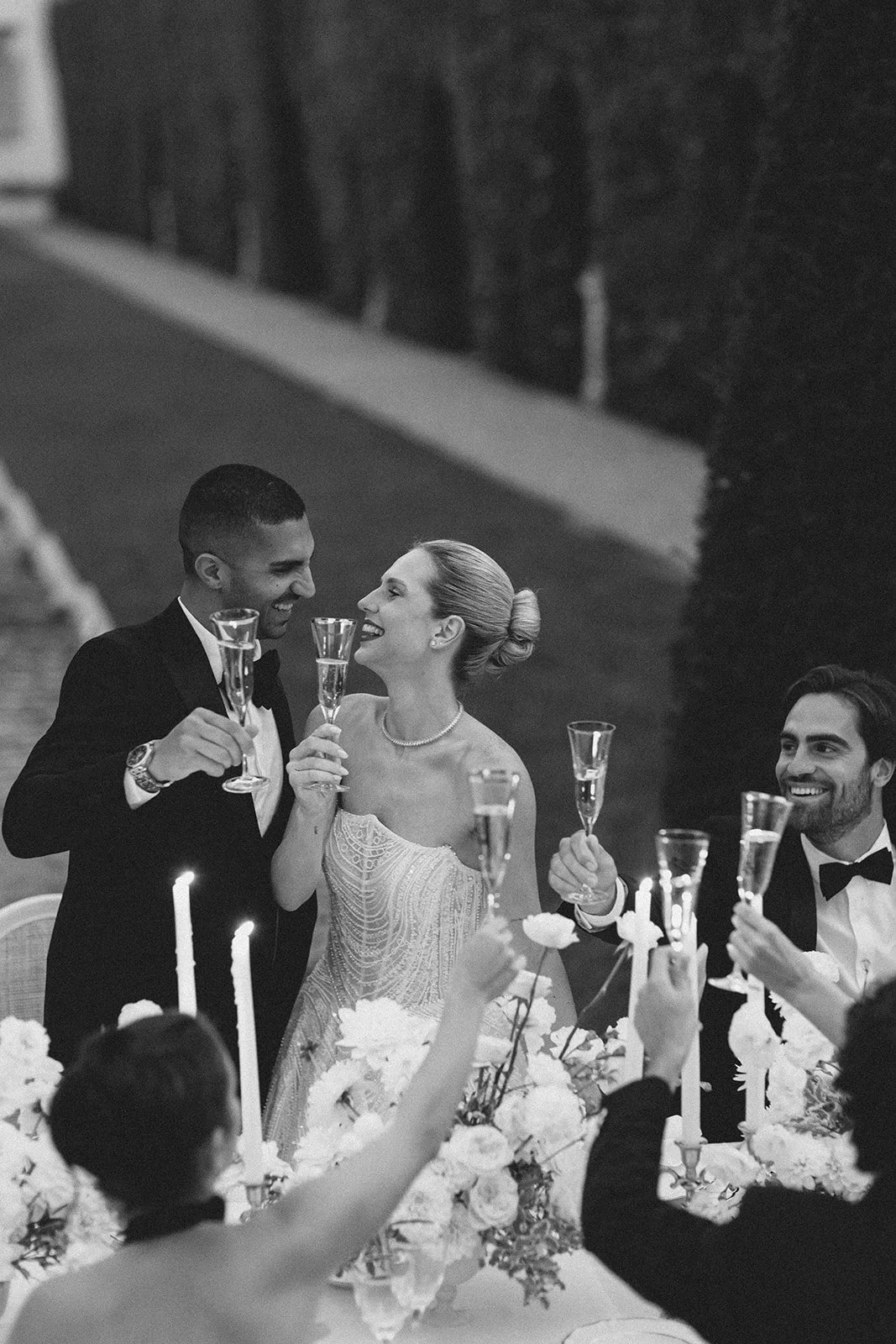 Bride, groom and guests sharing a champagne toast during an evening reception at Villa Balbiano.