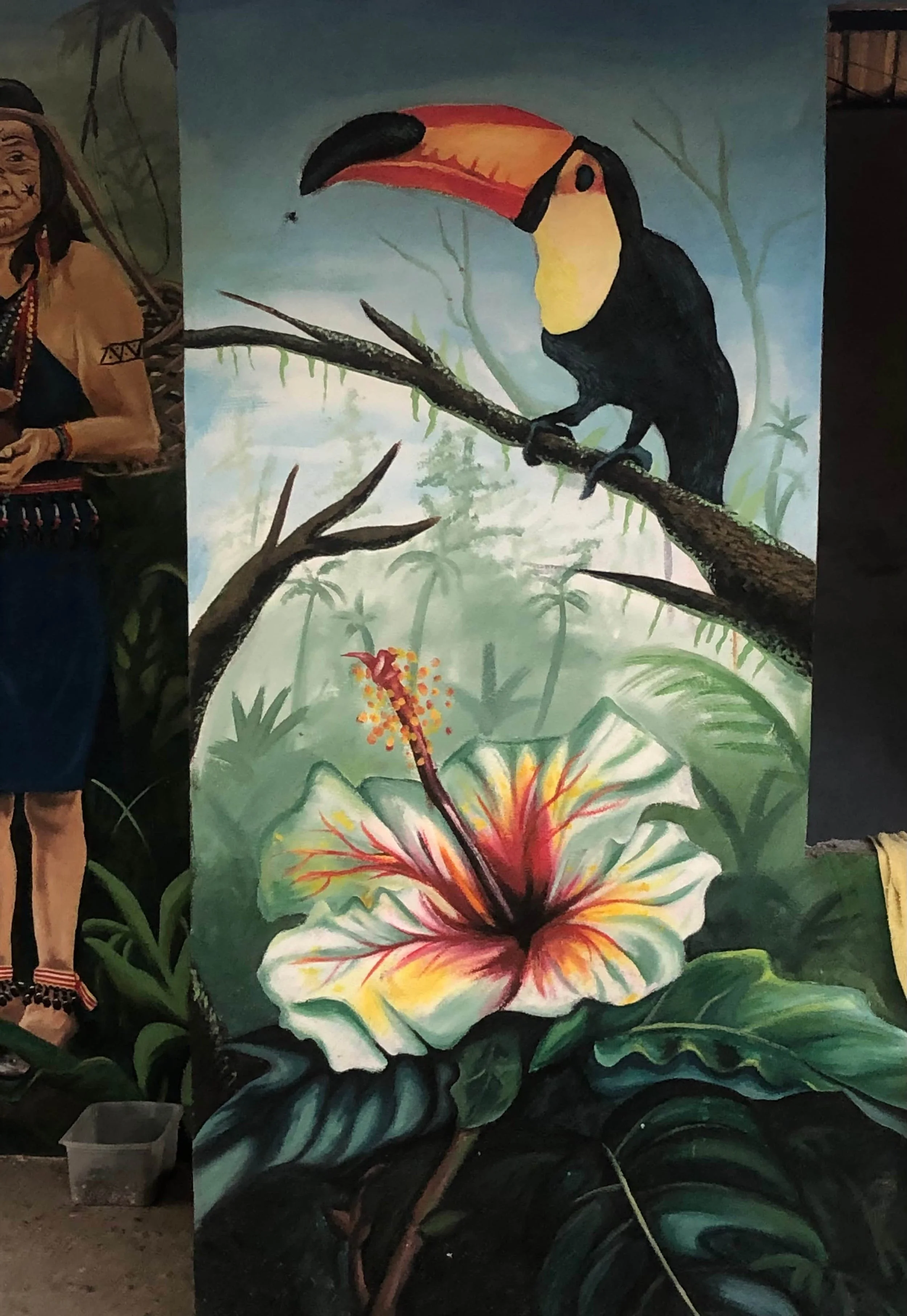 Arte Shuar. Fotografía de un mural en comunidad Shuar Masuk Las Vegas, cerca de Los Encuentros, Ecuador. La pintura es de un ave dela selva y una flor de hibiscus.
