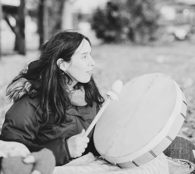 Black and white picture of Carmen Sánchez playing her drum