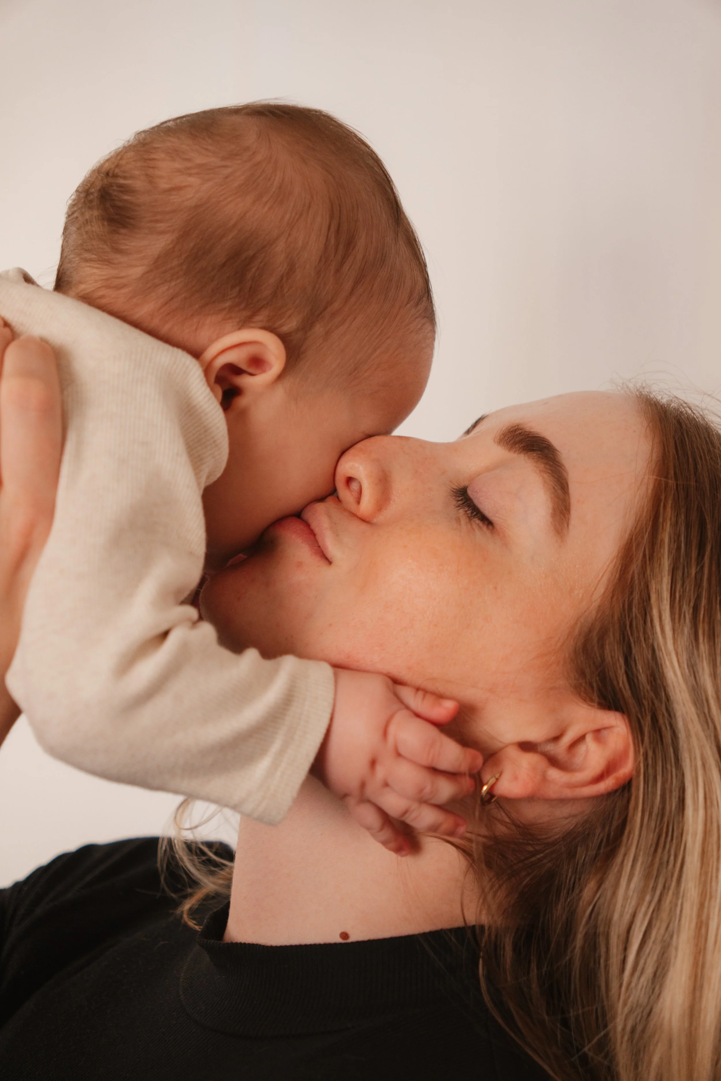 Mother and baby in a tender moment and mother lifts baby up